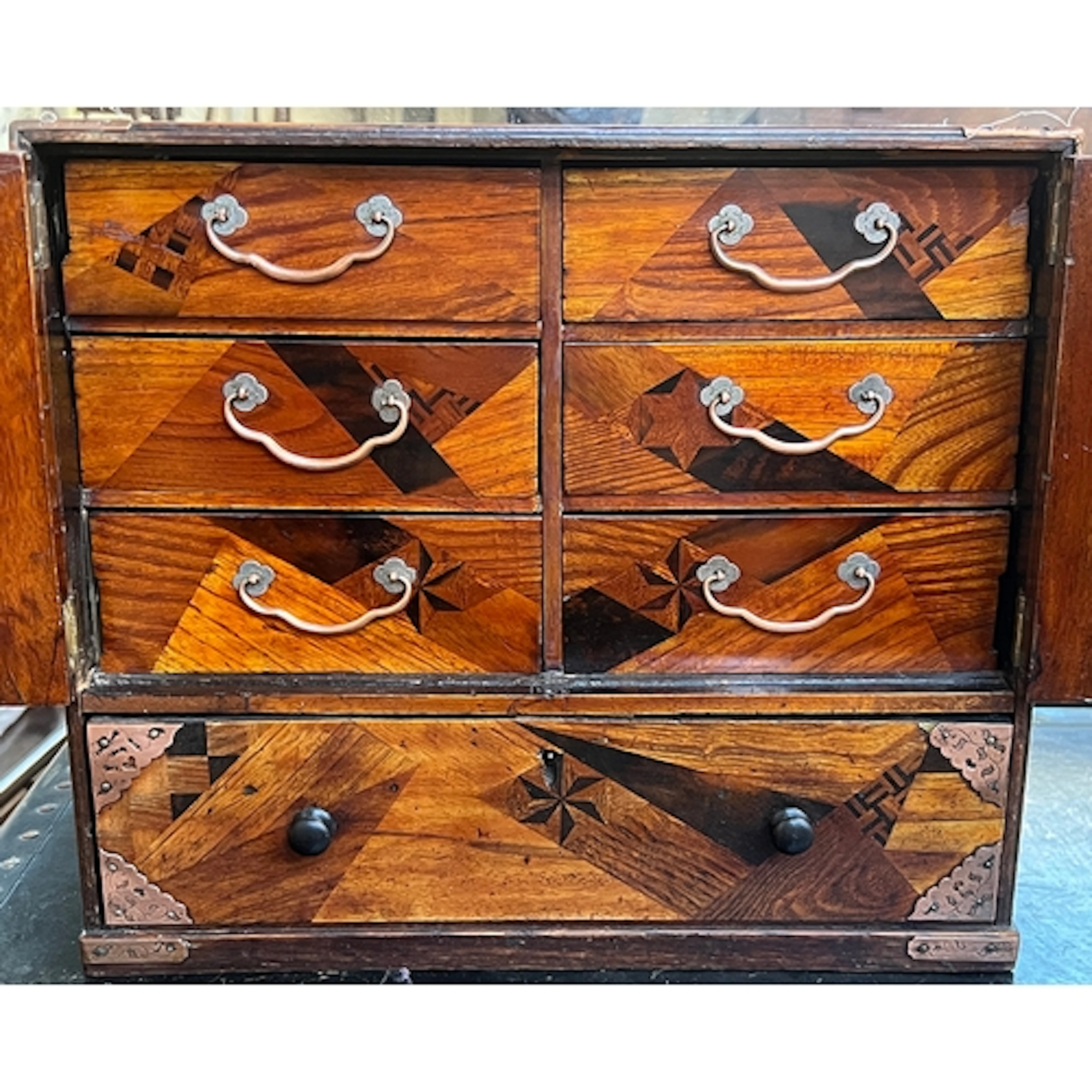A Japanese parquetry table cabinet, two cupboard doors openi...