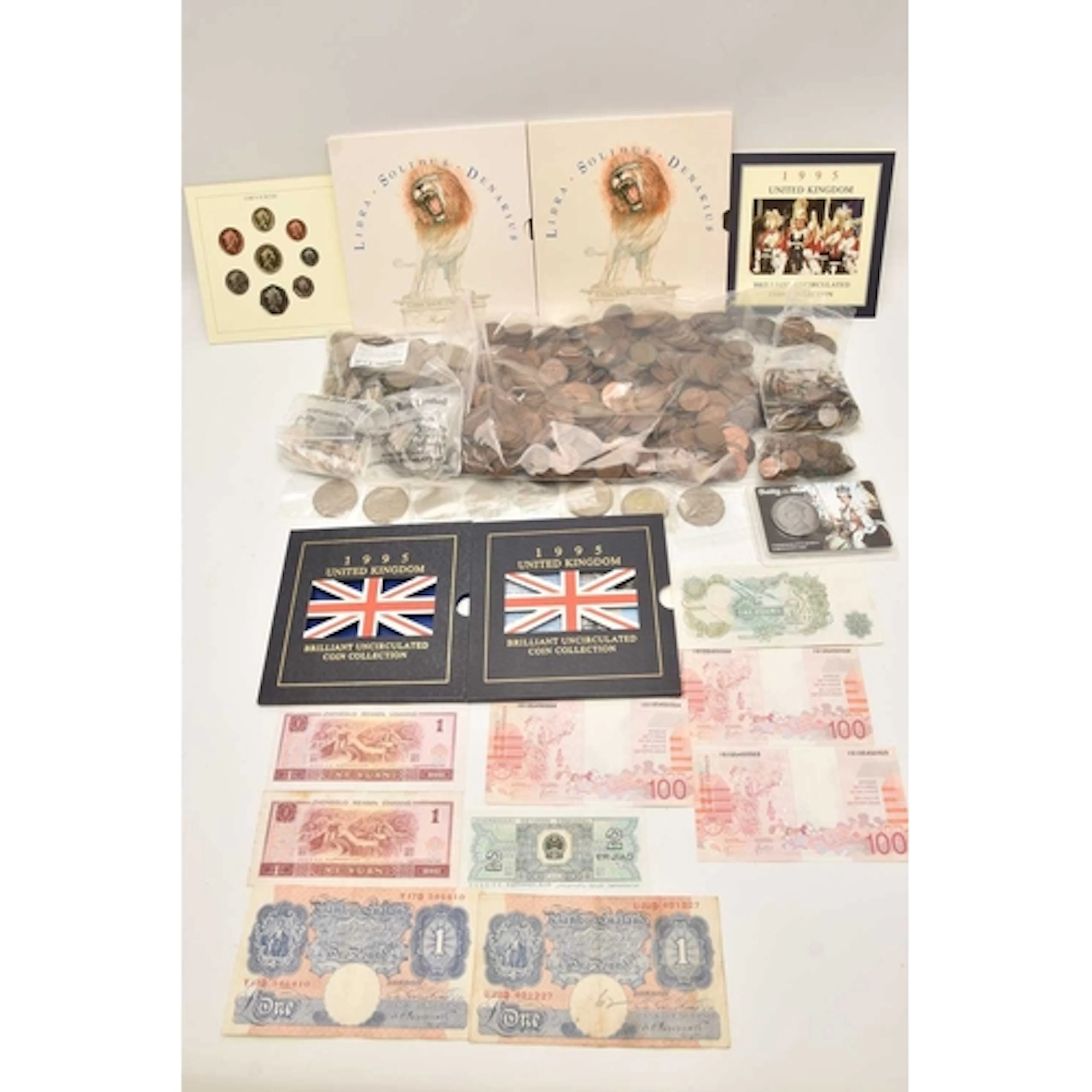 A plastic case containing coins and banknotes. Noted are 2 x...