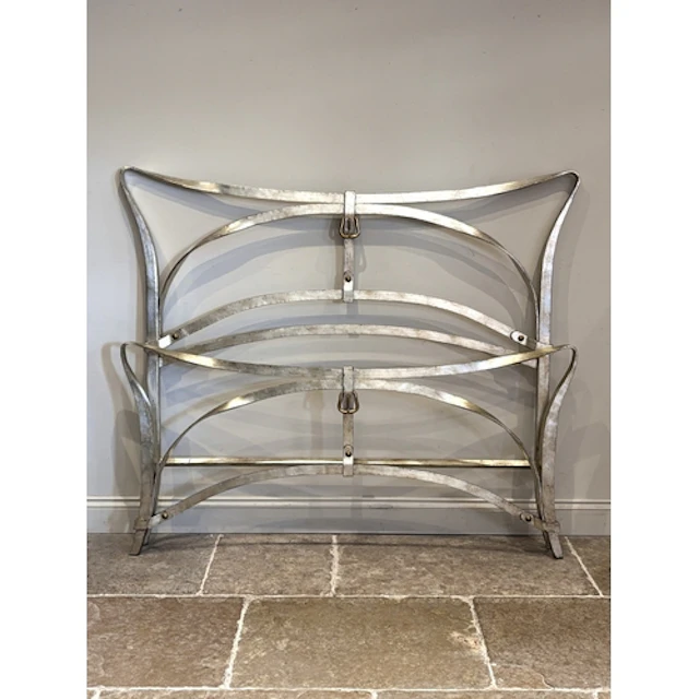 A painted wrought iron king size bed, designed as interlaced...