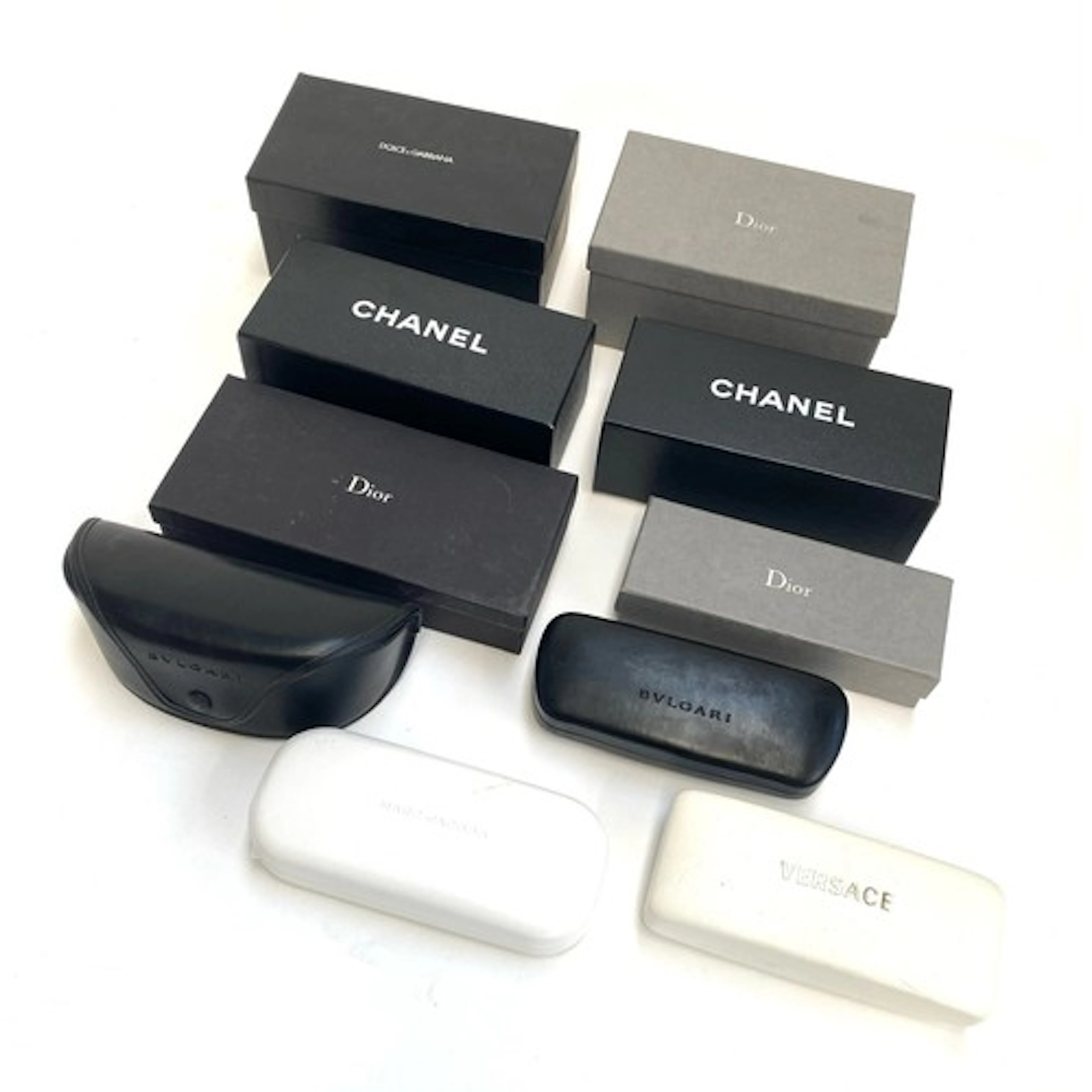 A collection of empty designer sunglasses cases and boxes, t...