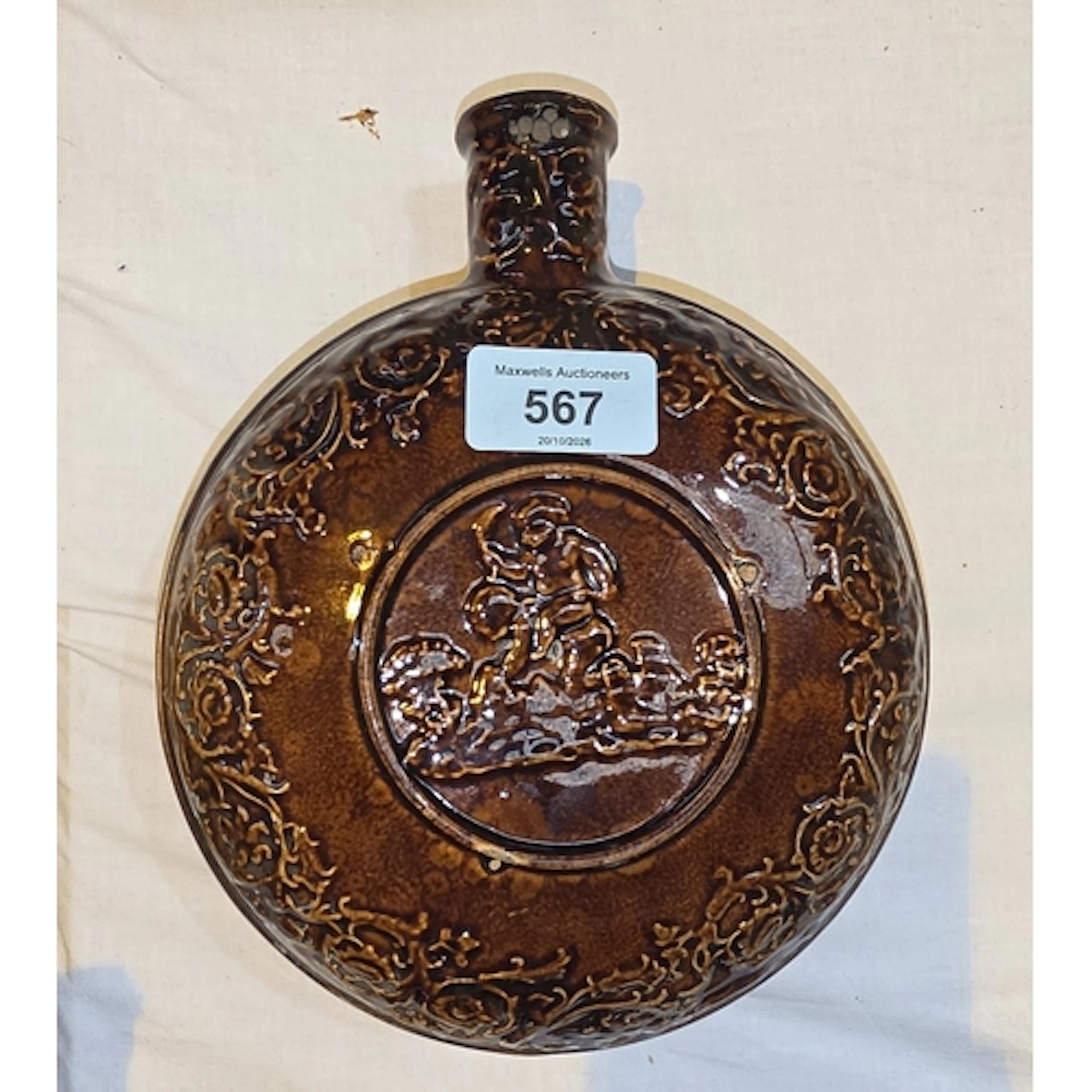 A 19th century Rockingham treacle glaze moon shaped flask wi...