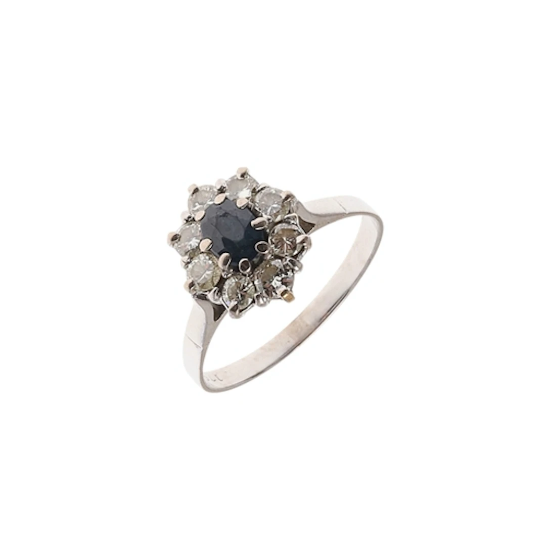 A SAPPHIRE AND DIAMOND CLUSTER RING. the oval-shaped sapphir...