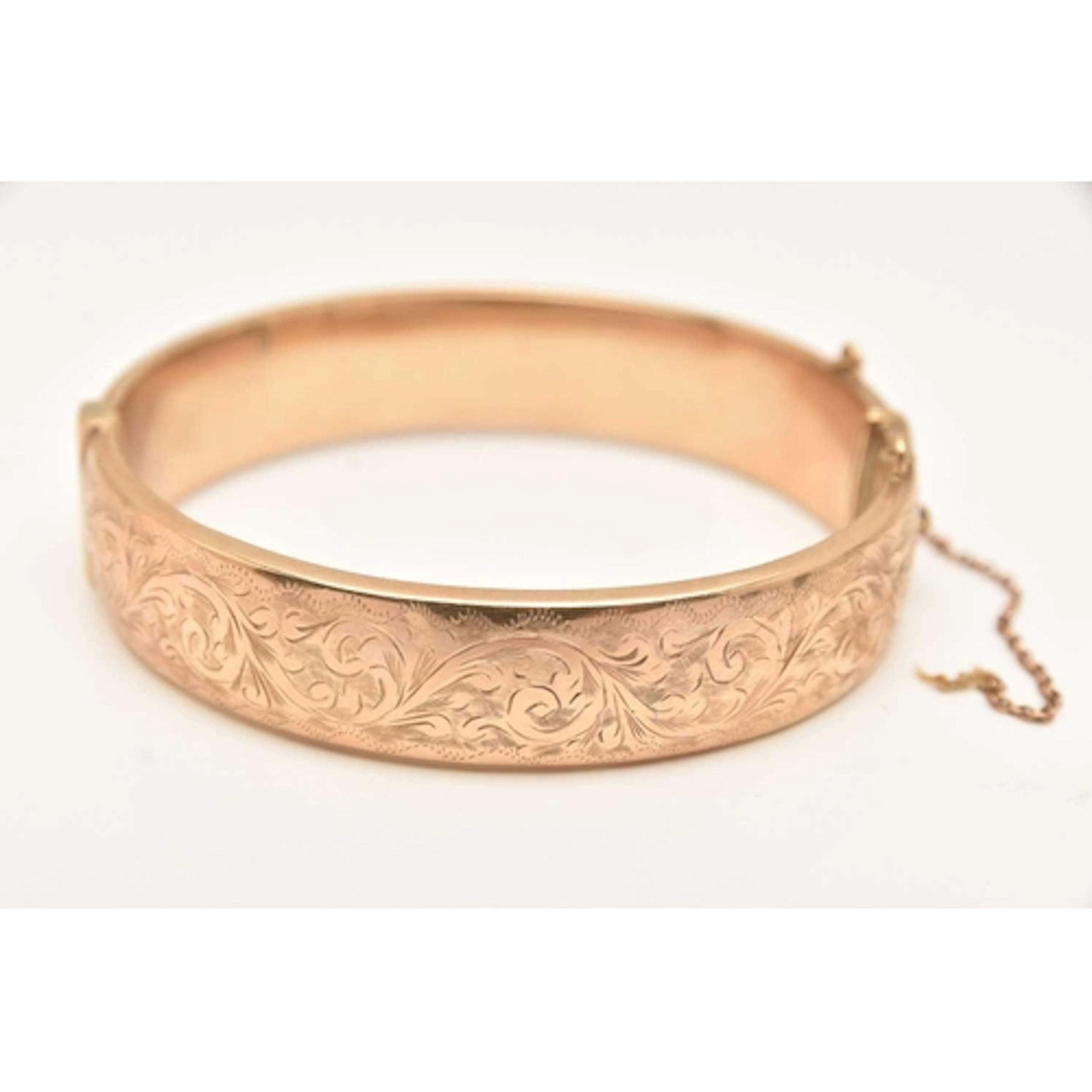 A YELLOW METAL HINGED BANGLE, with floral pattern, push butt...
