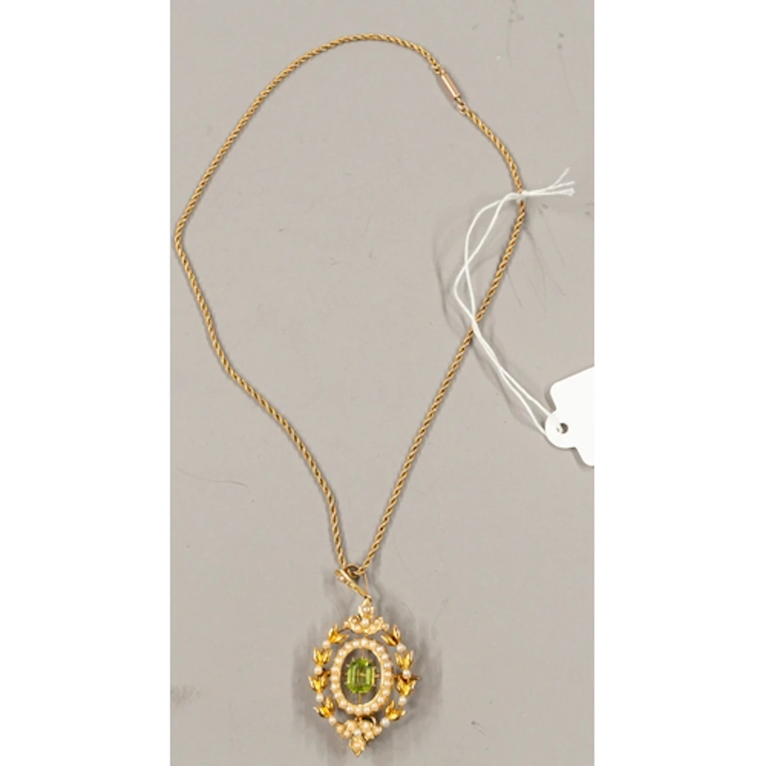 Jewellery: a yellow metal pendant brooch, set with a central...