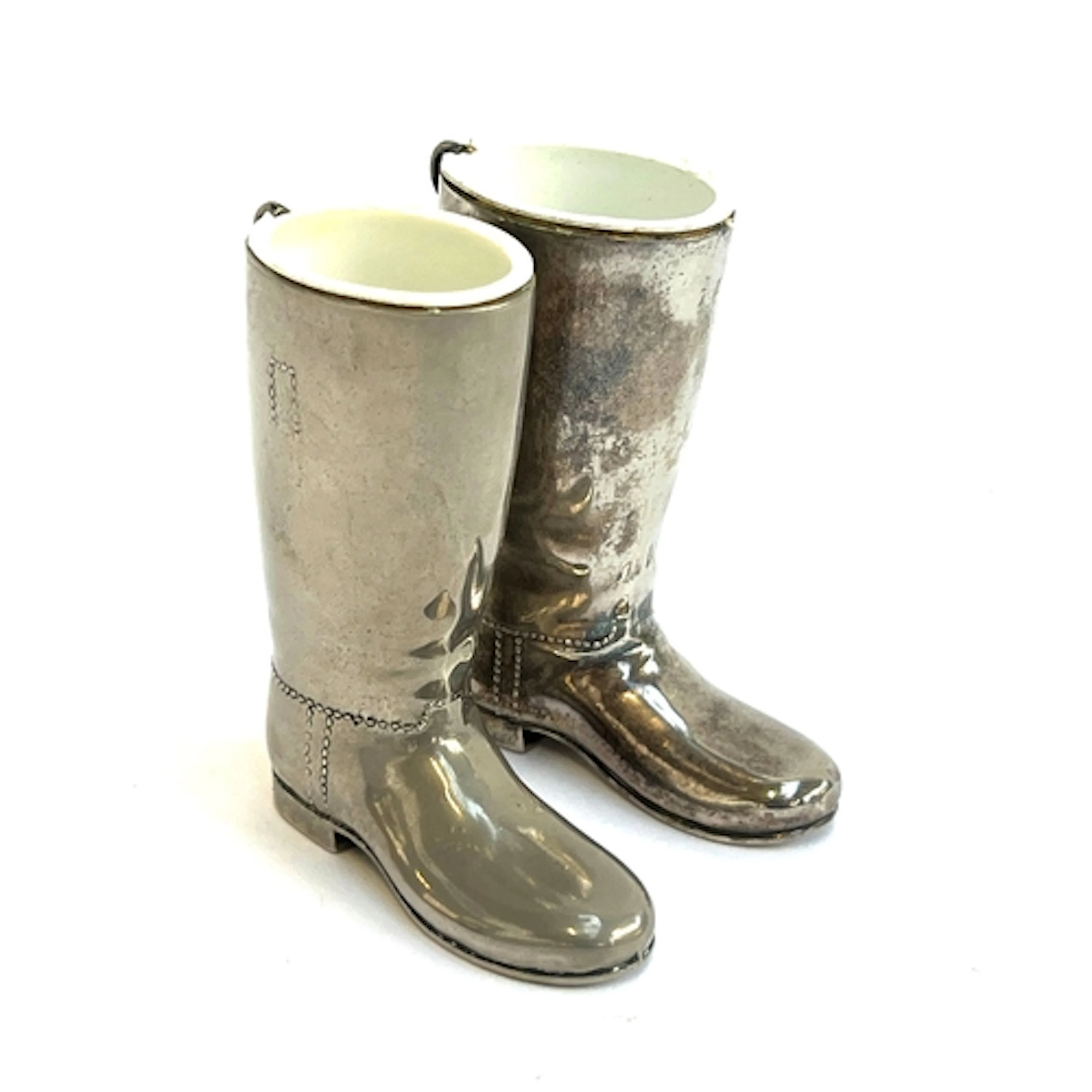 A pair of silver plated spill vases in the form of boots, 8....
