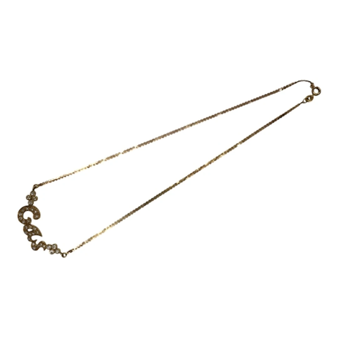A gold and diamond necklace, centring on the name 'Cas', set...