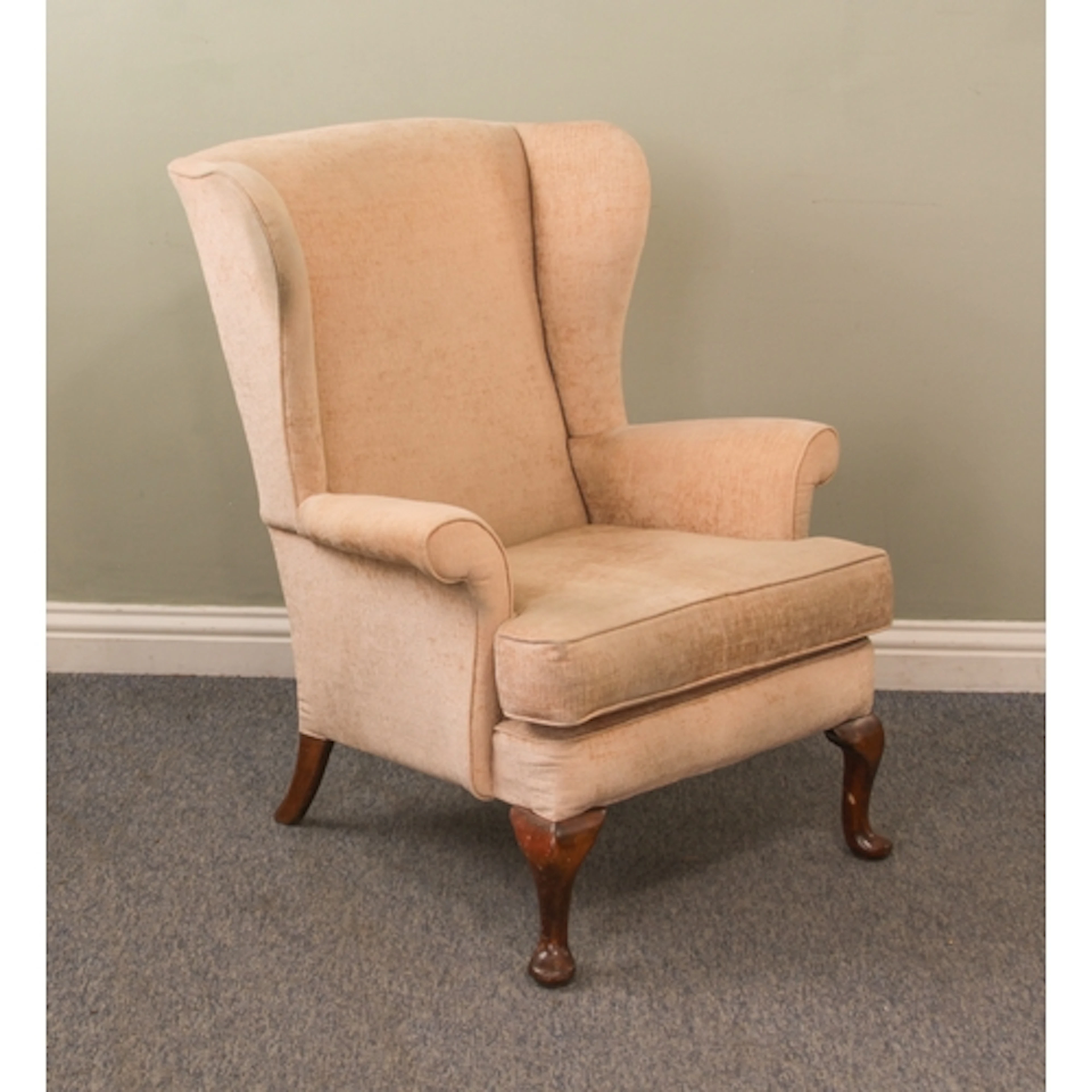 A Parker Knoll wingback armchair - upholstered in pale gold ...