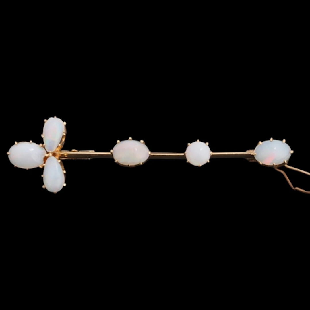 A 14ct gold opal bar brooch, claw set with oval and pear cab...