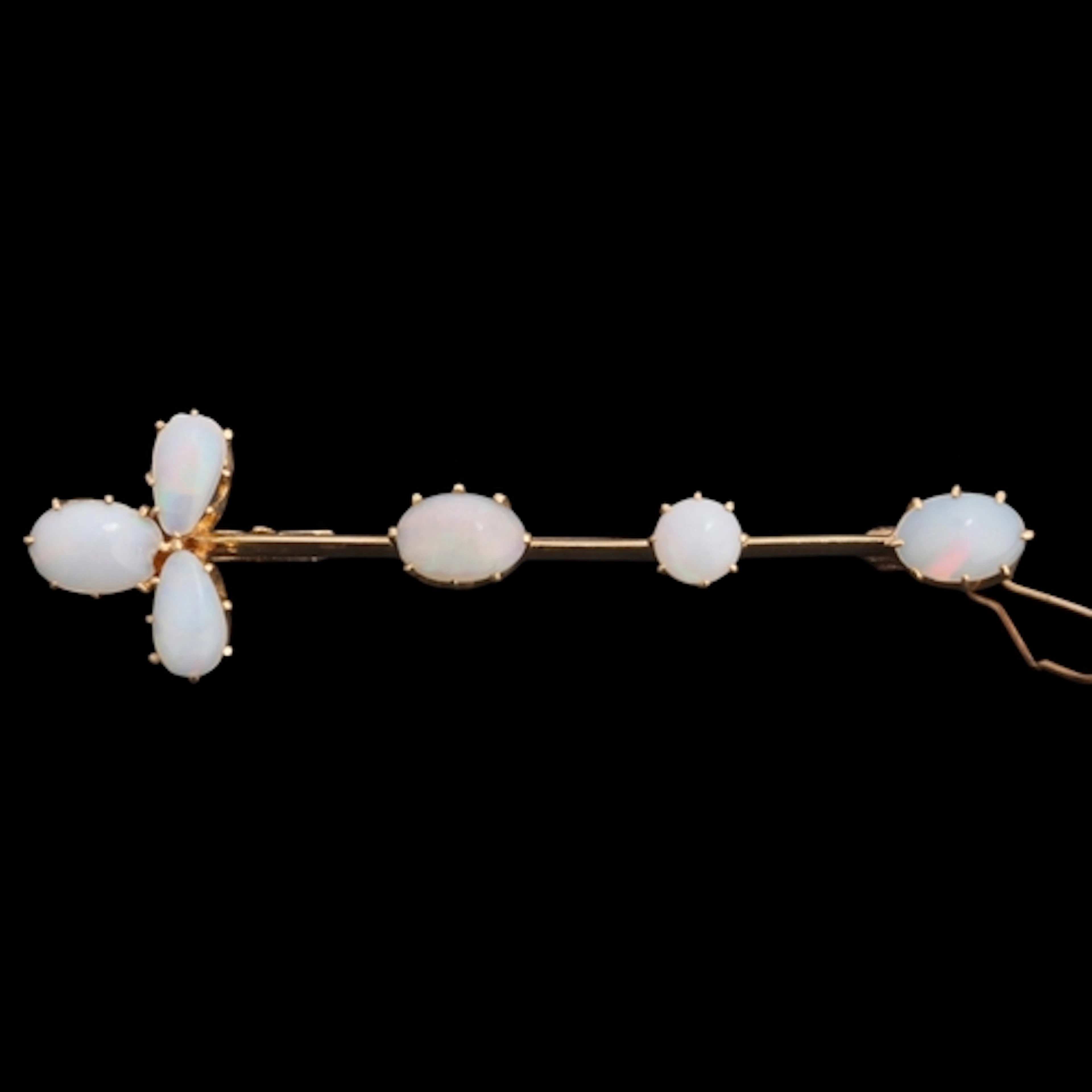 A 14ct gold opal bar brooch, claw set with oval and pear cab...