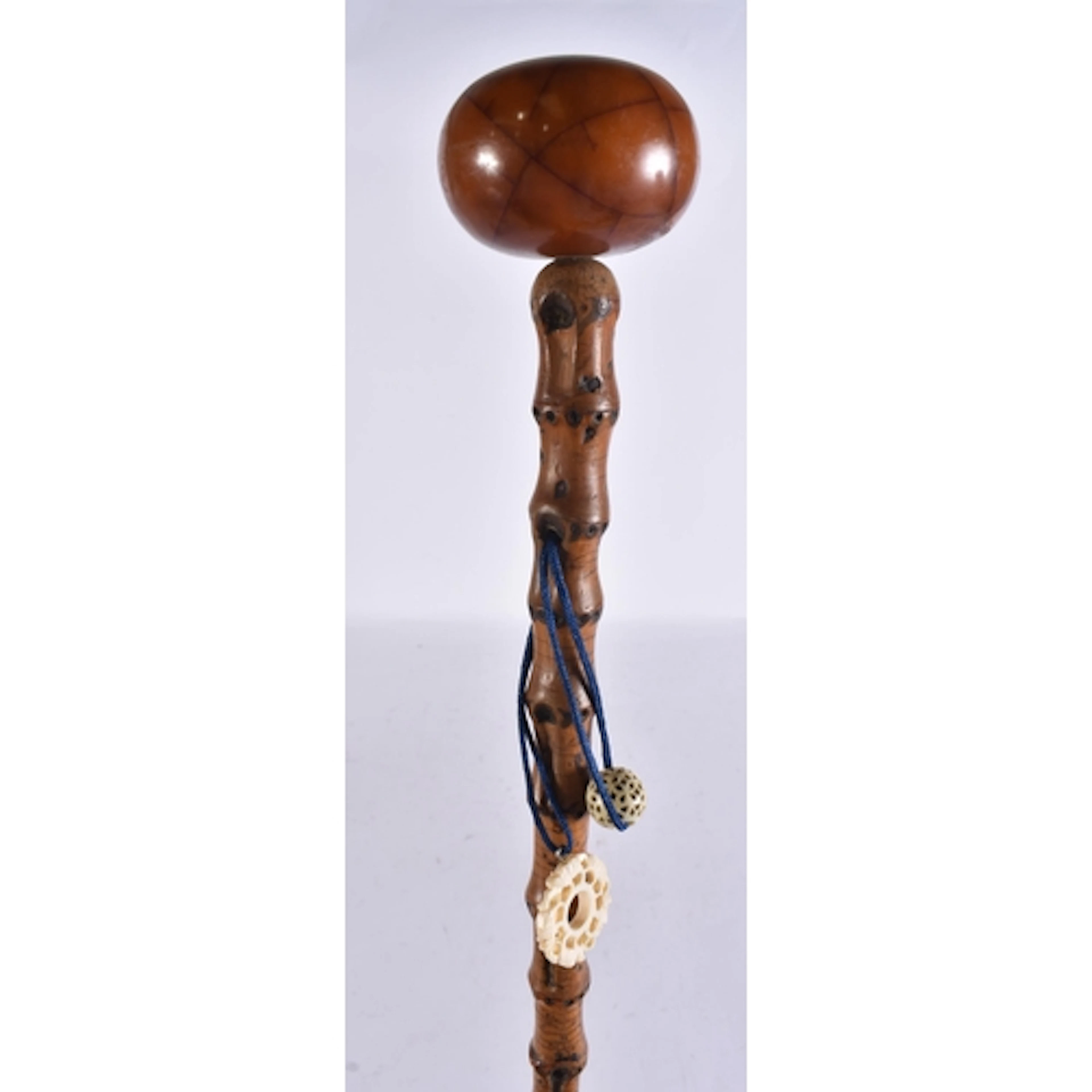 AN ANTIQUE AMBER BAKELITE TOPPED WALKING CANE. 82 cm long.