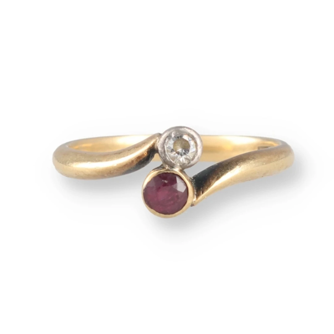 AN 18CT GOLD RUBY AND DIAMOND CROSSOVER RING Weight: 2.8gms ...