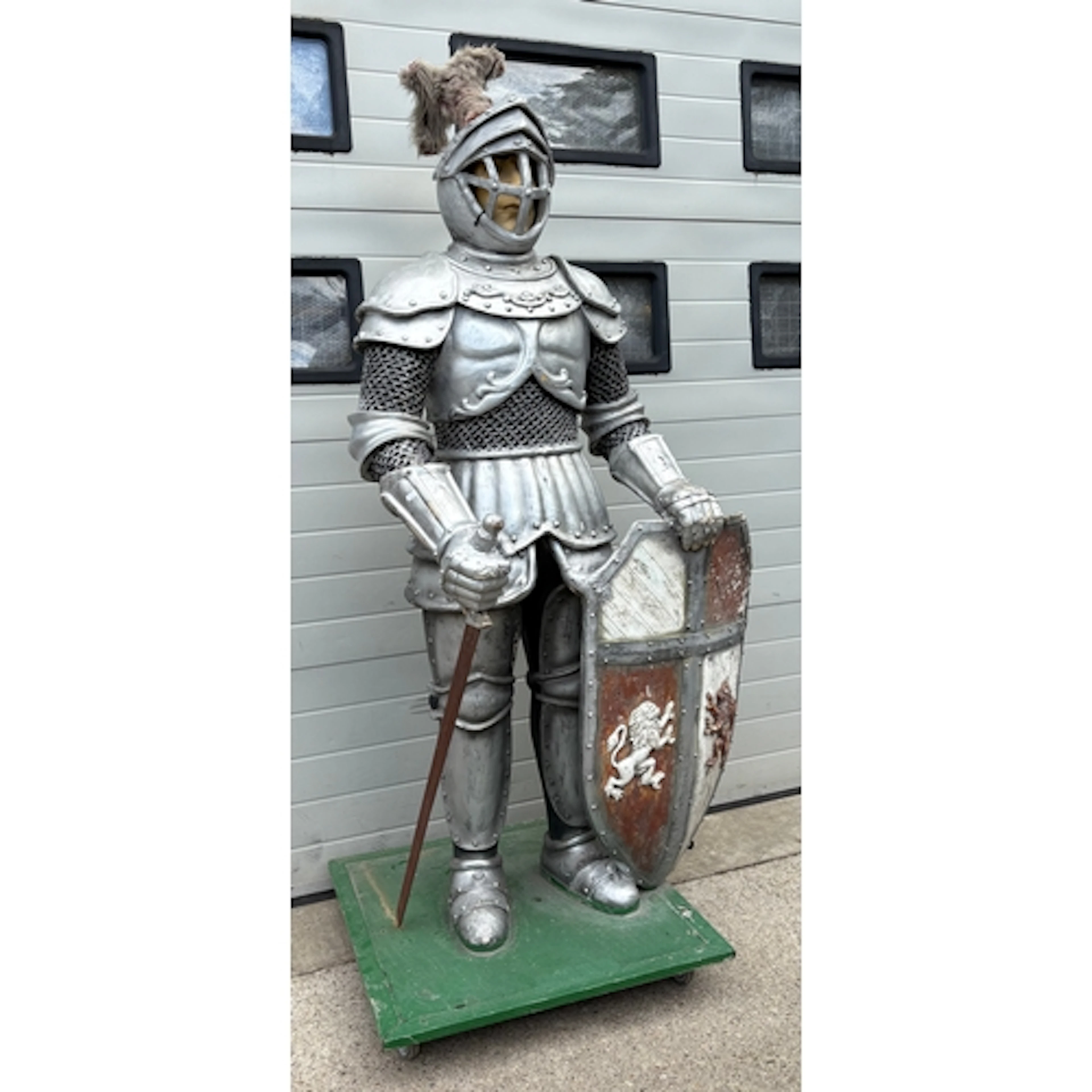 A life-size silver-finish medieval knight prop with a shield...