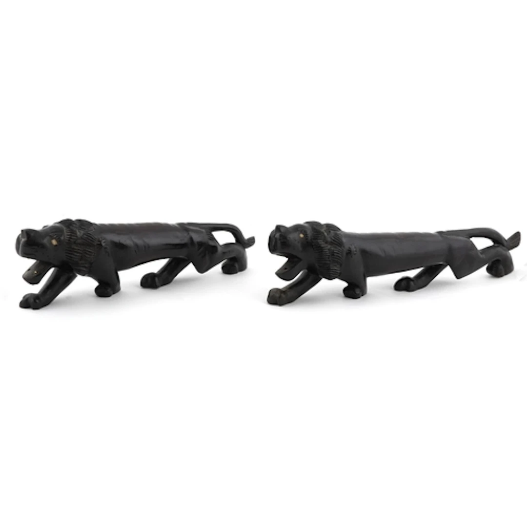Two large wooden hand carved crouching African lions, the la...