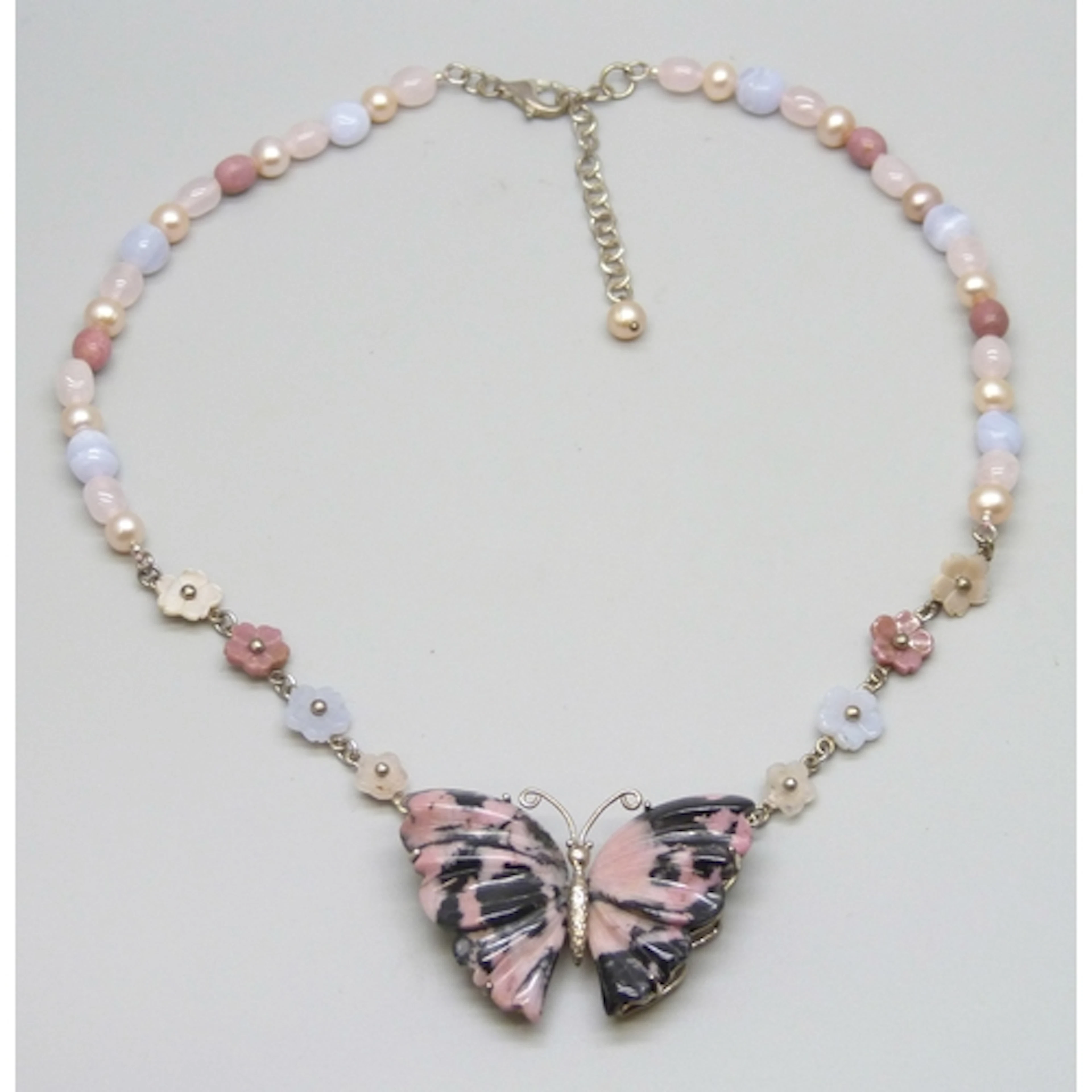 A statement silver and gemstone necklace with flower design ...