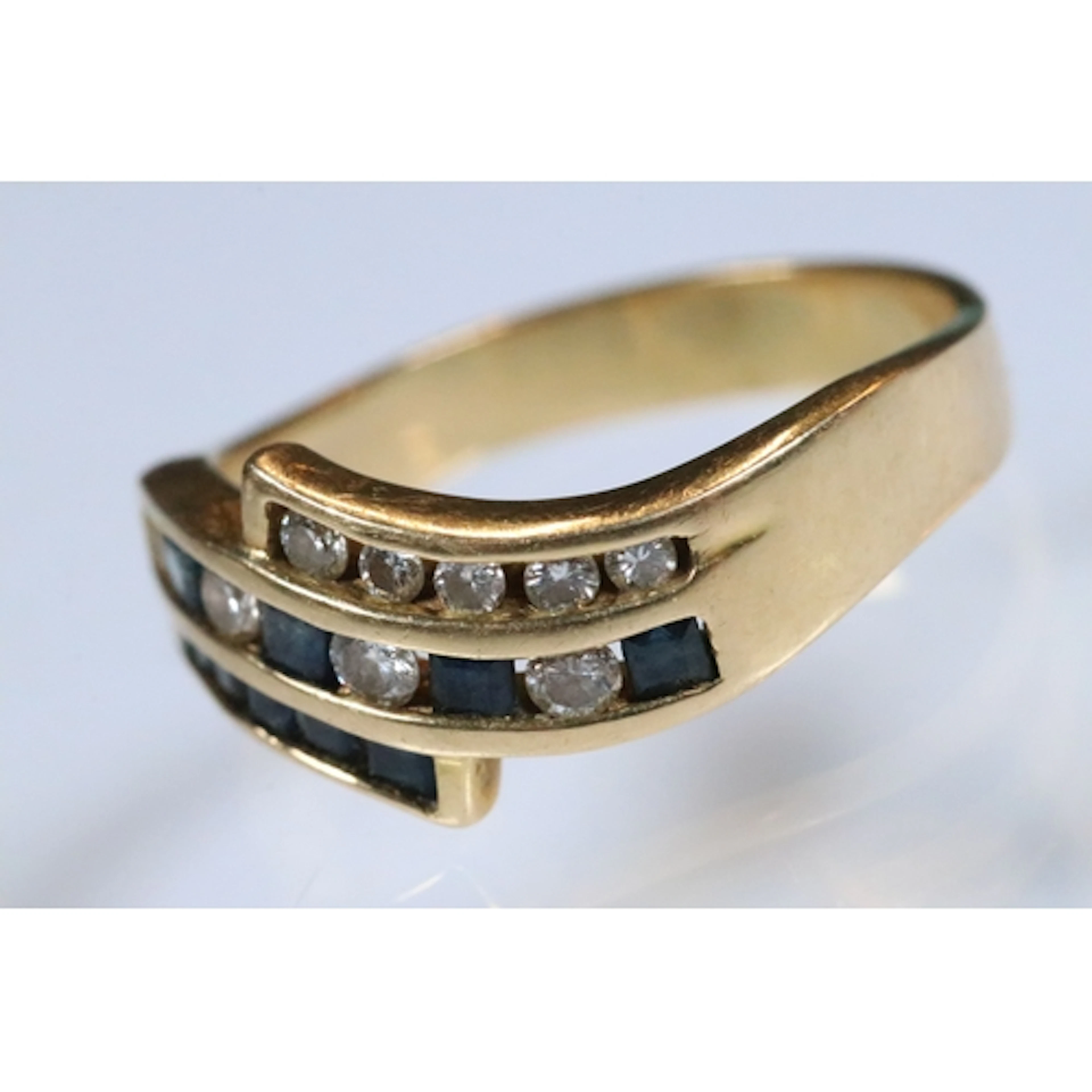 18ct gold, sapphire and diamond ring. The ring being channel...