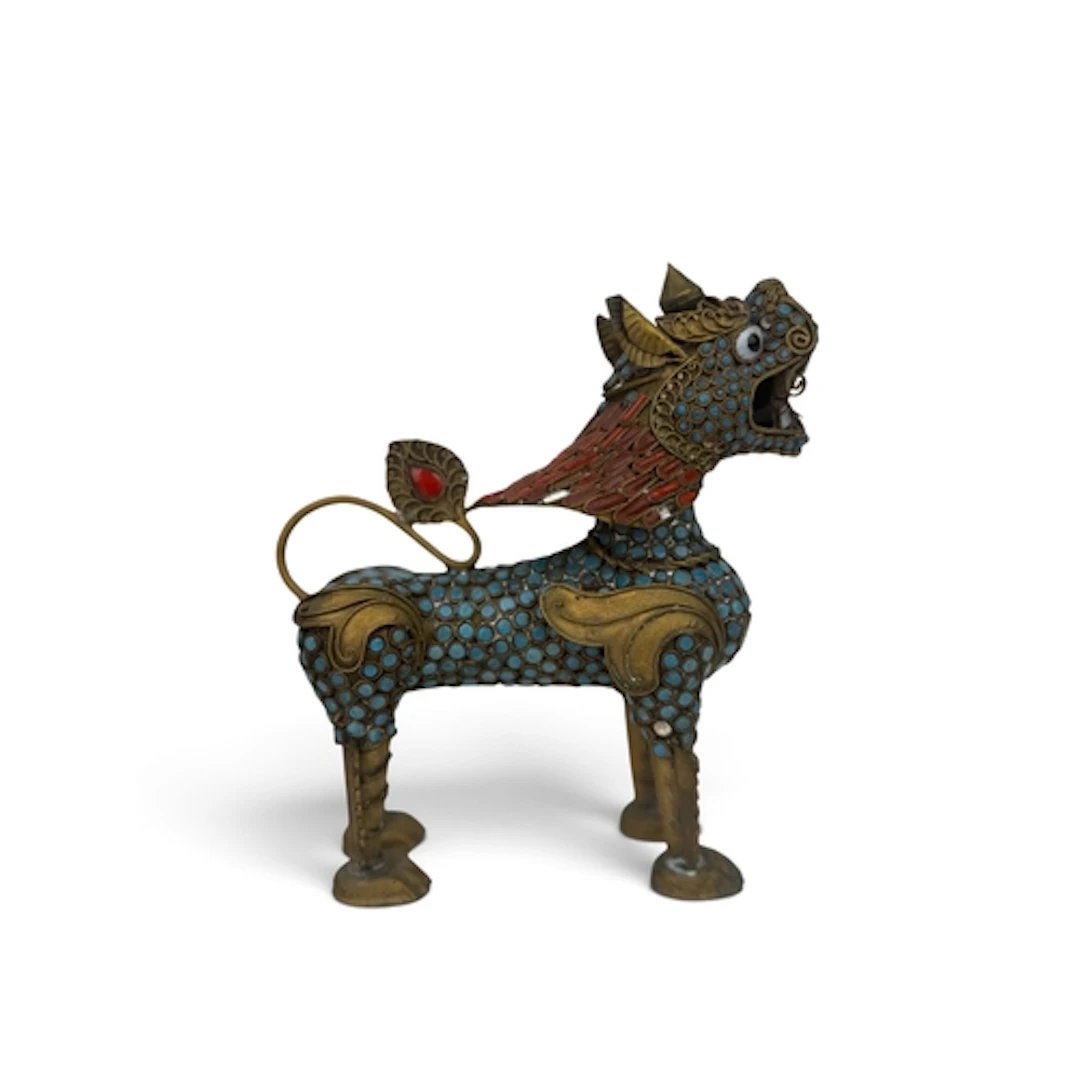A 20TH C NEPALESE GILDED METAL GUARDIAN FO TEMPLE LION, INSE...