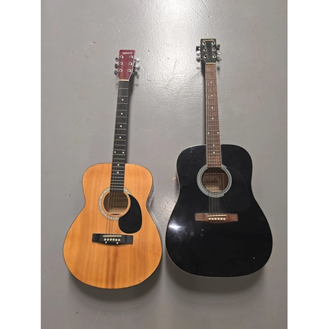 A Gremlin black acoustic guitar together with an elevation a...