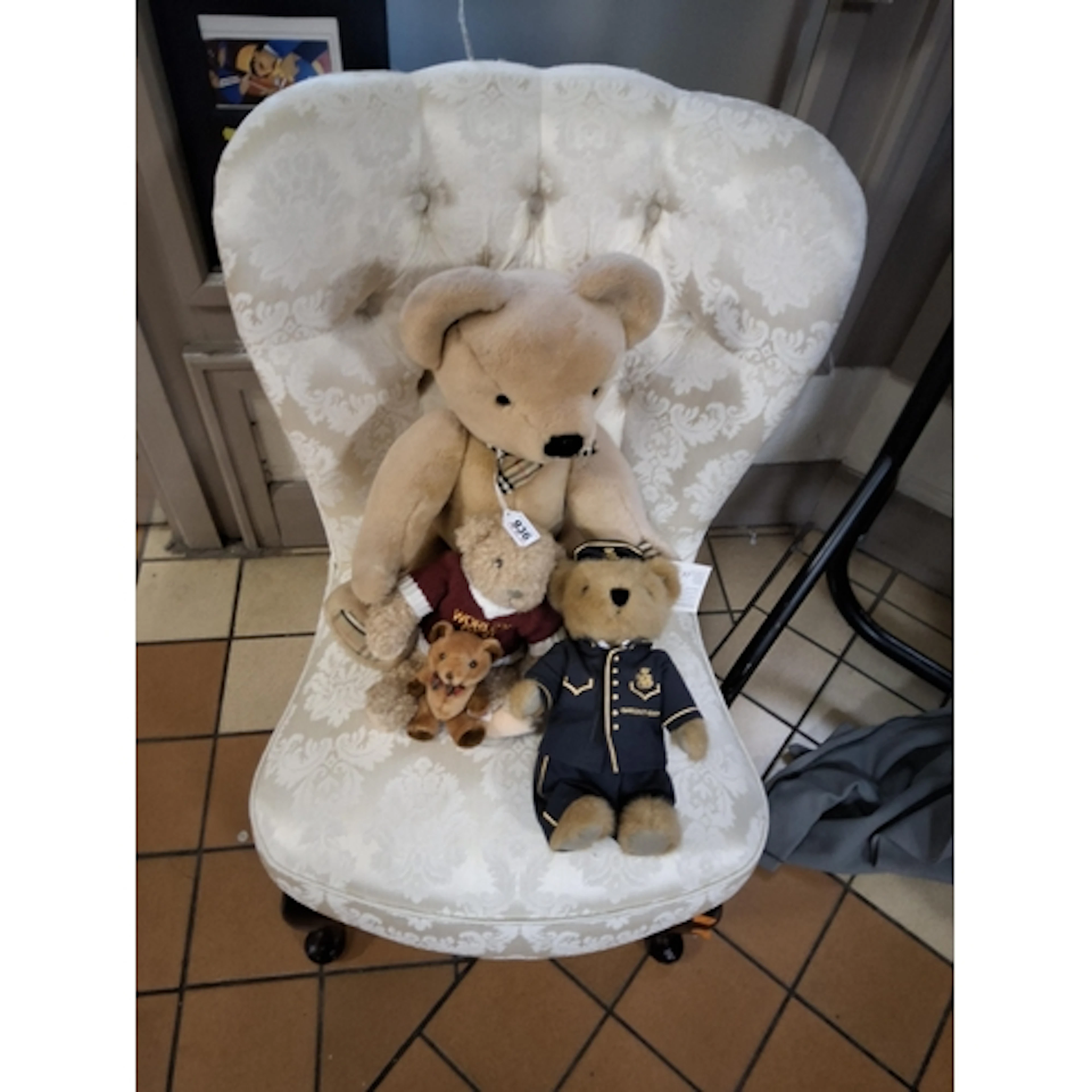A GROUP OF FOUR TEDDY BEARS ON A CHAIR comprising a large Bu...