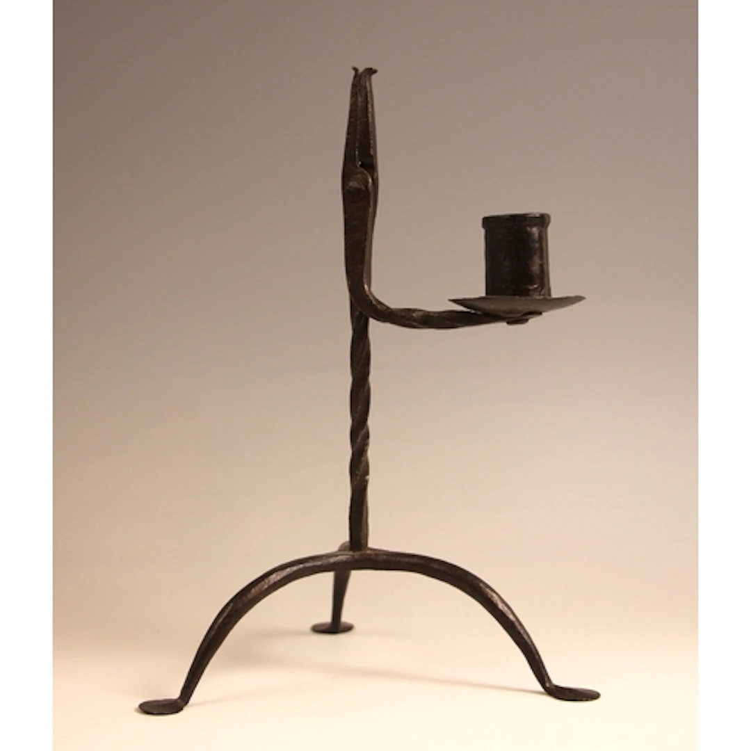 A wrought iron combination rush light and candle holder, lat...