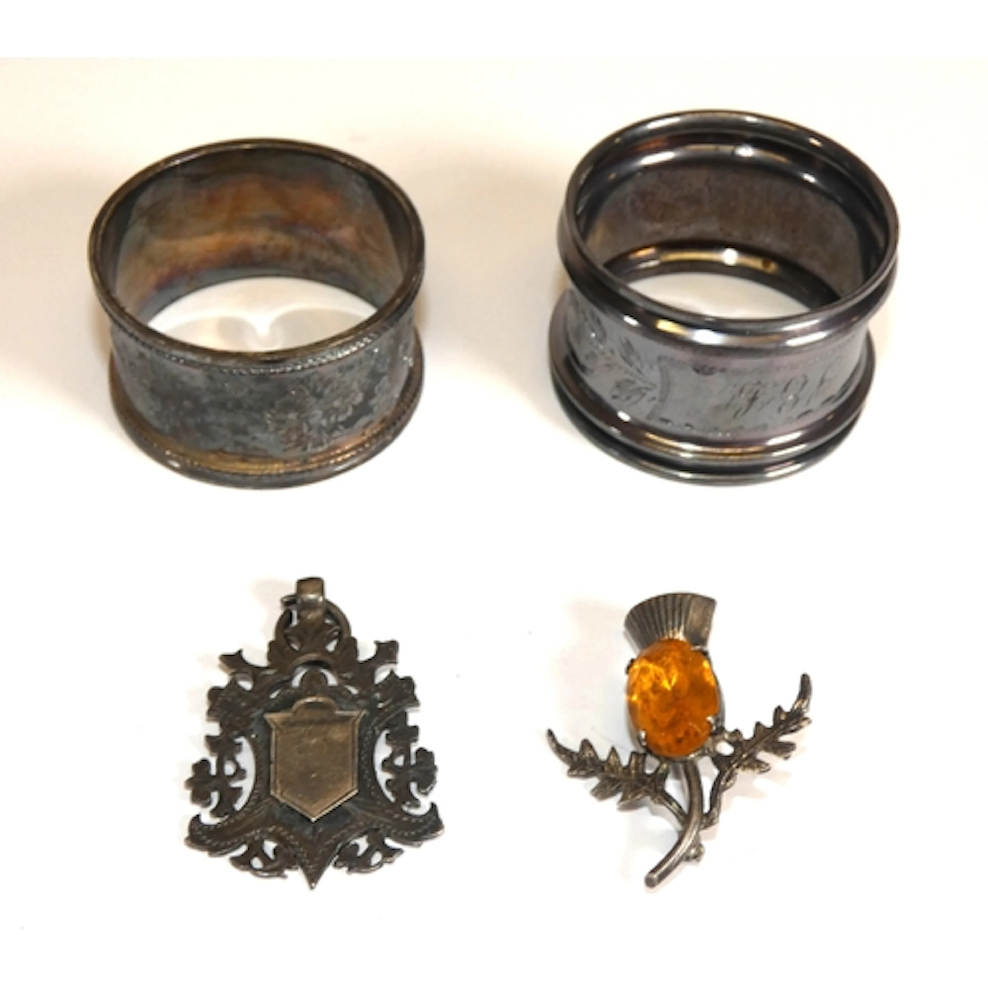 Two silver napkin rings, silver medal fob, and silver cairng...