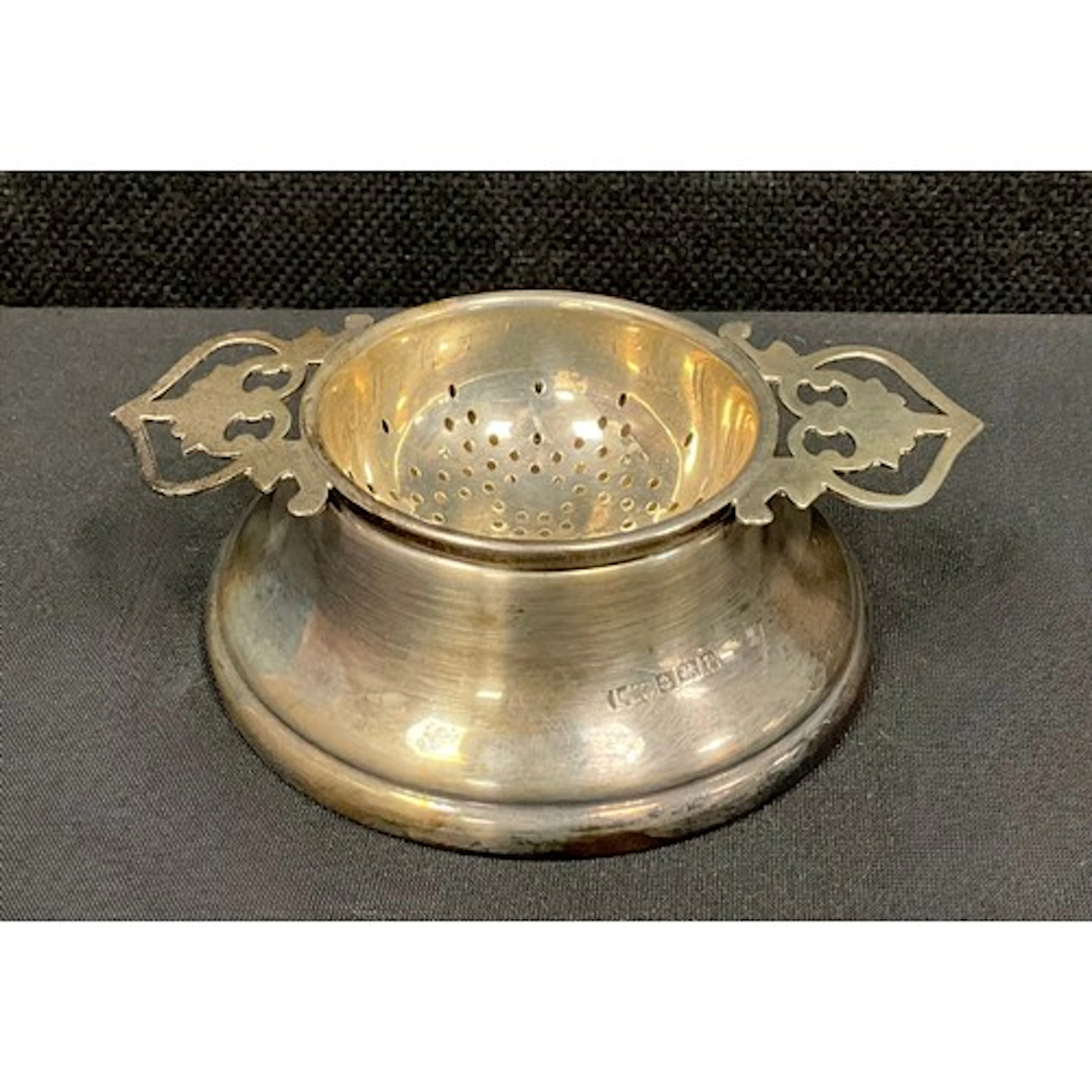 An Elizabeth II silver tea strainer on stand, Lanson Ltd, Bi...