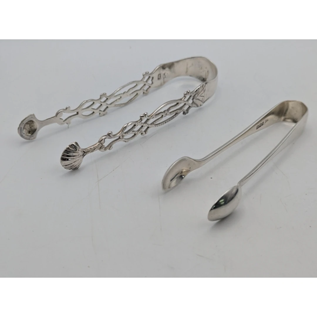Two sugar tongs, one decorated with a coat of arms, hallmark...