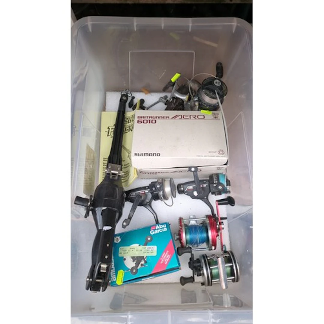 A collection of fishing reels and an Instant Fisherman compa...