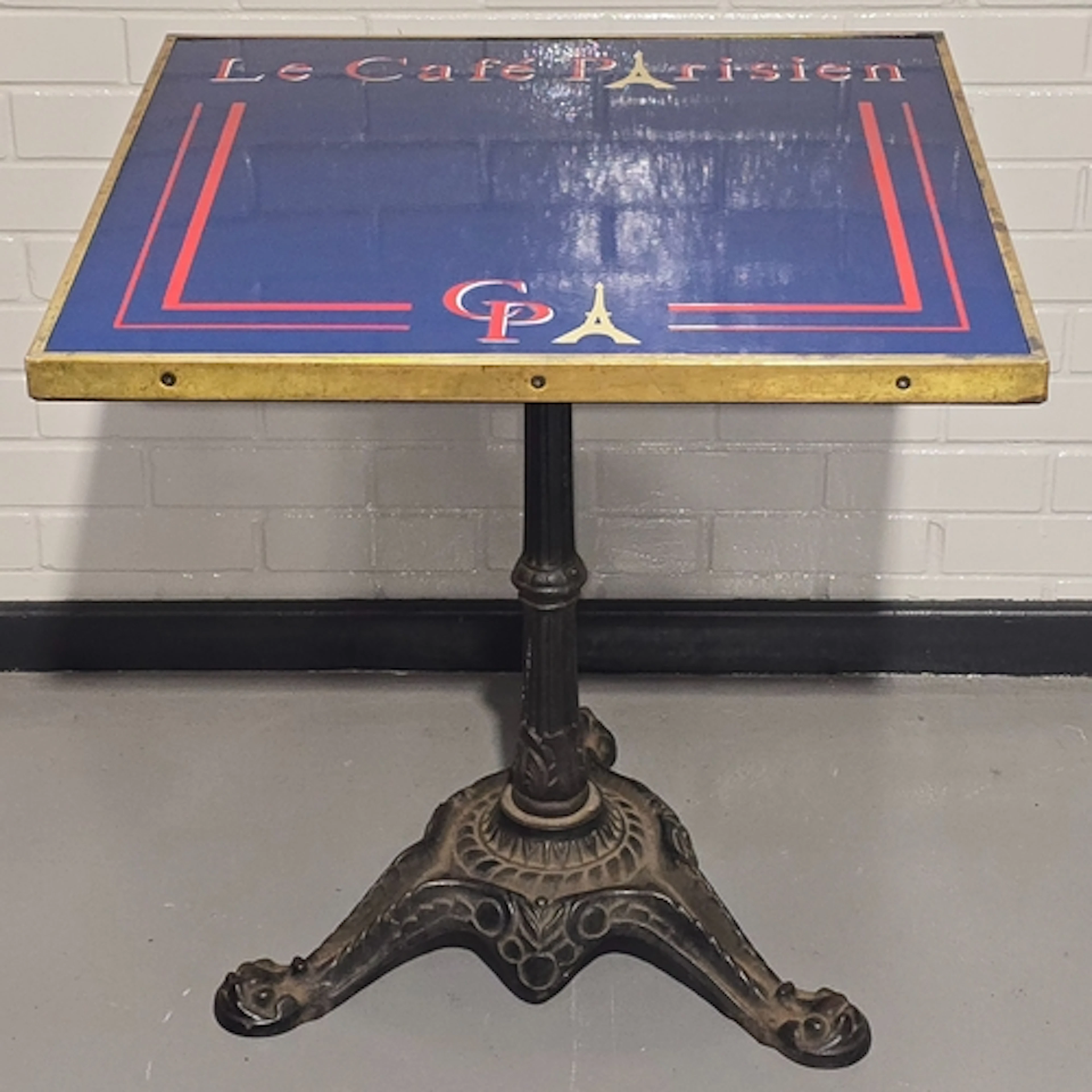 A vintage bistro table resting on heavy antique cast iron ba...