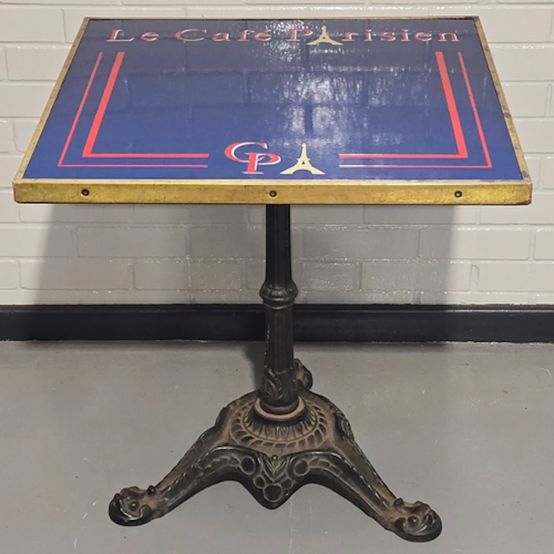 A vintage bistro table resting on heavy antique cast iron ba...