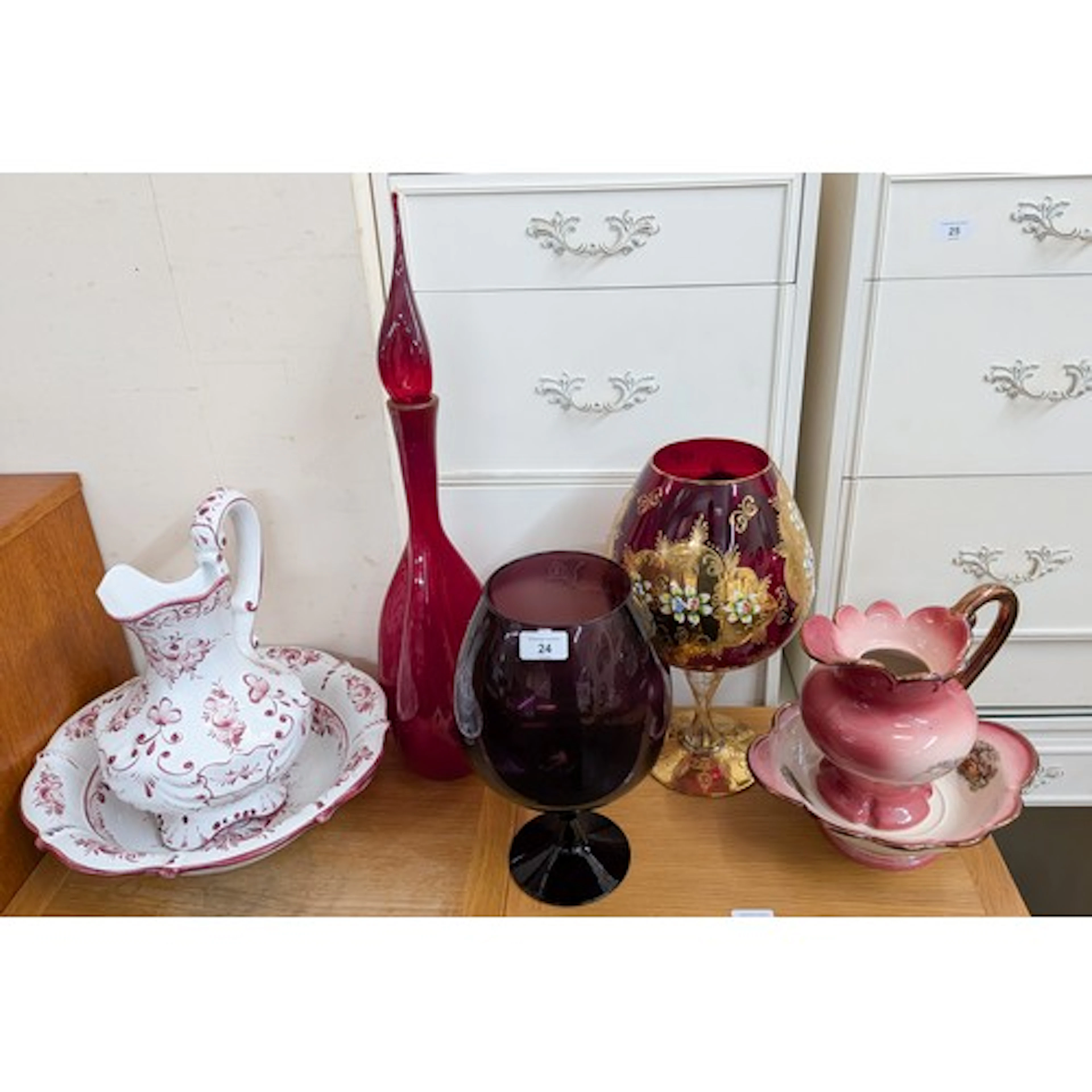 Two toilet jugs and basins together with a large red glass v...