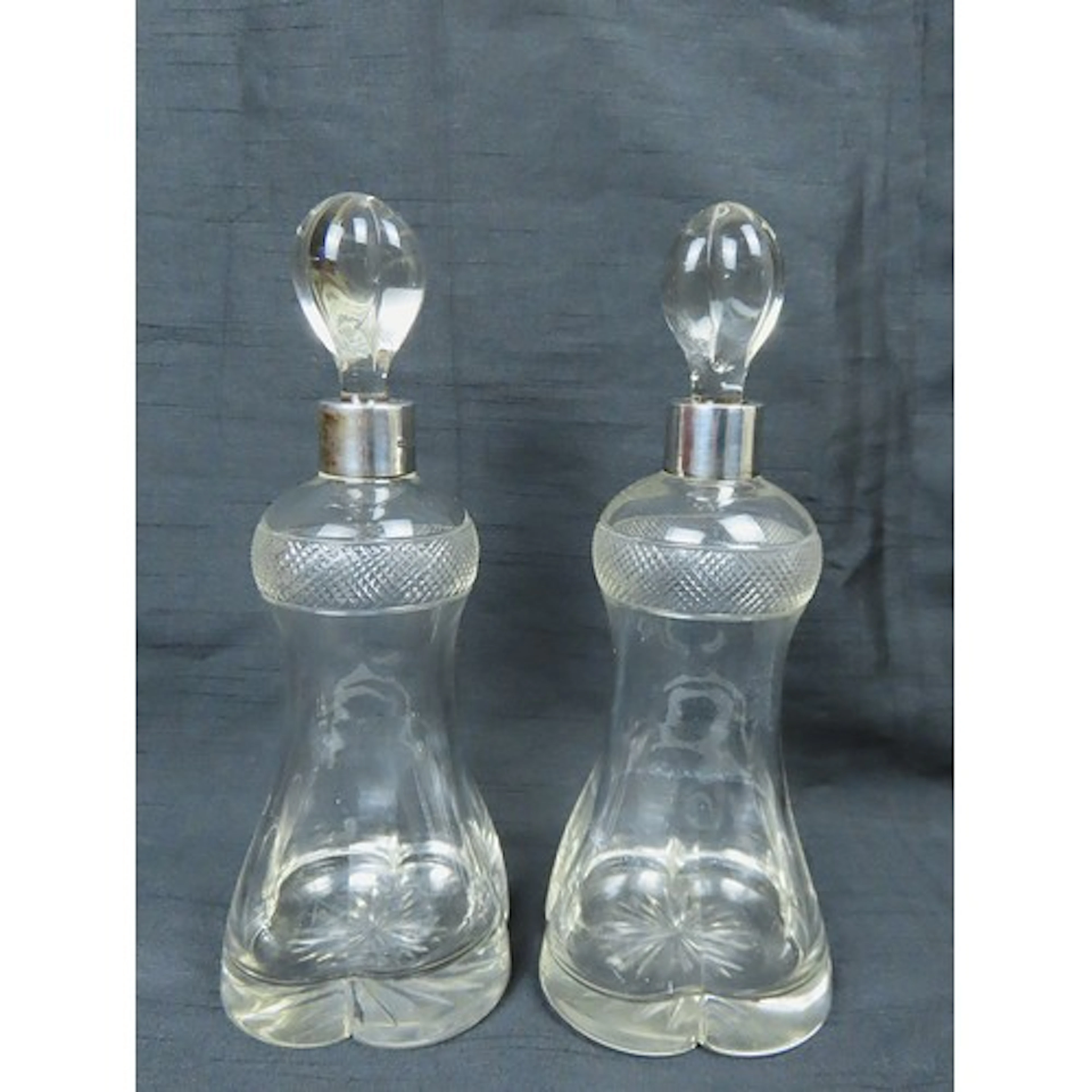 A PAIR OF ELEGANT SILVER MOUNTED QUATREFORM GLASS DECANTERS ...