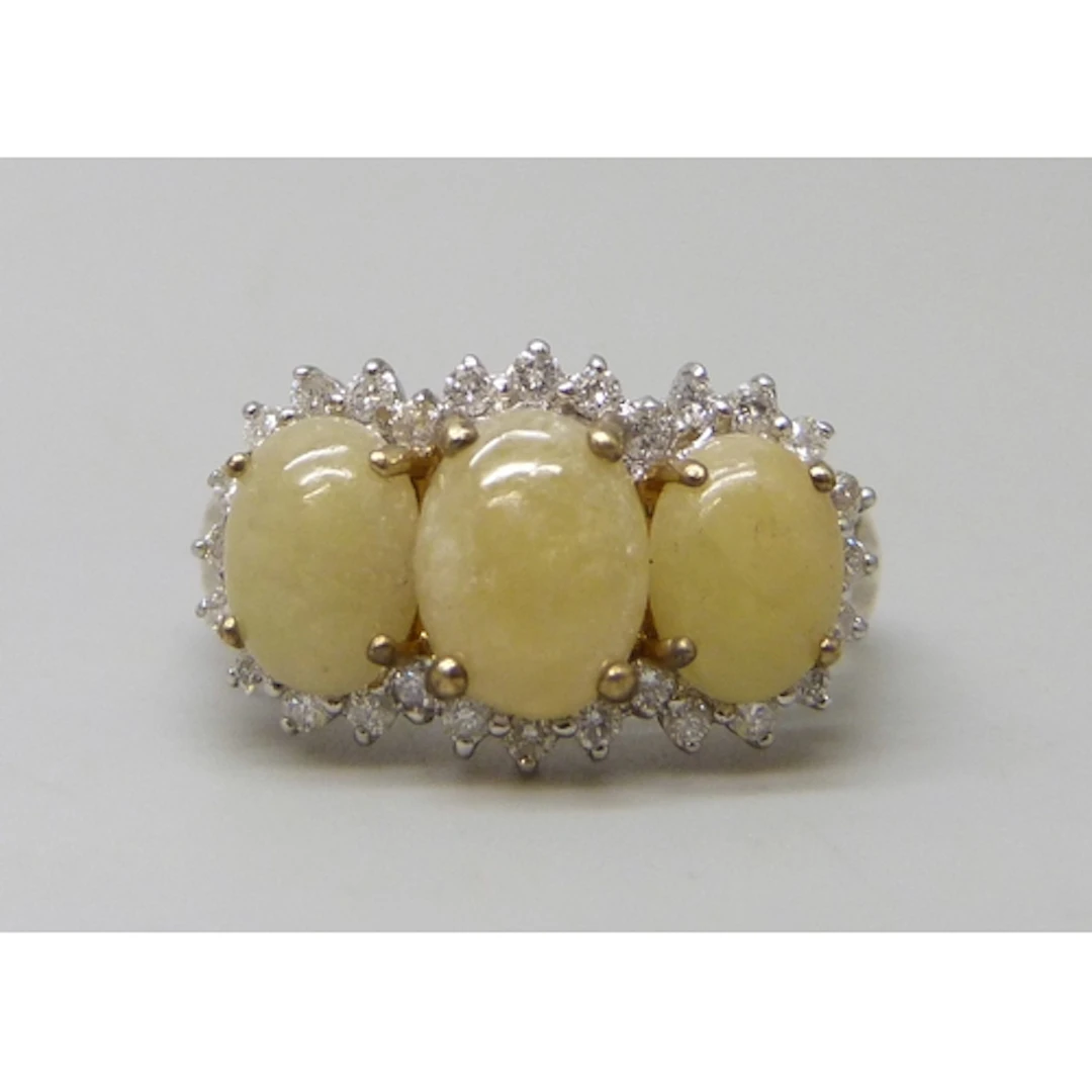 A 9ct gold three stone ring with diamond border, 2.8g, M