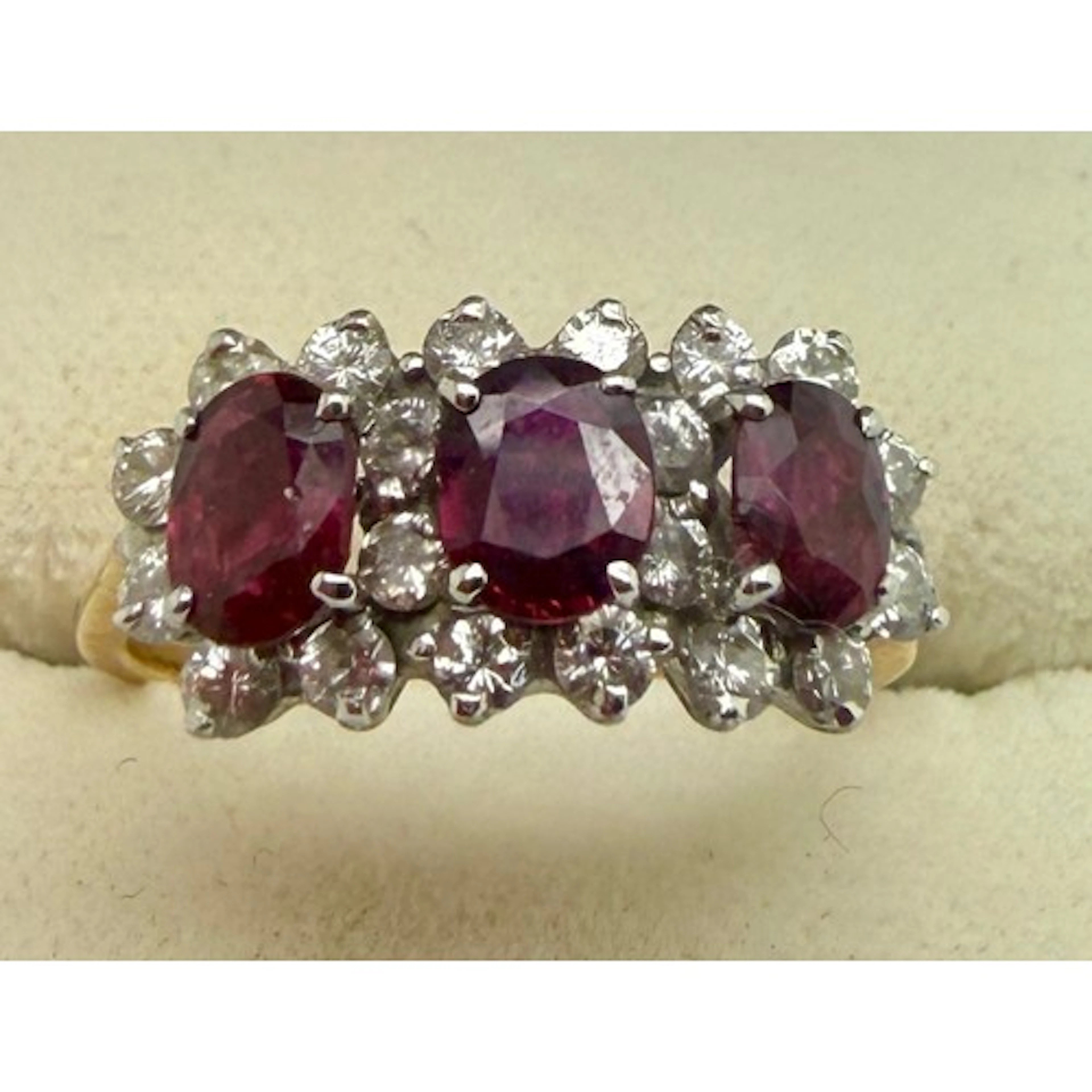 A diamond and ruby triple cluster ring set in 18 carat yello...
