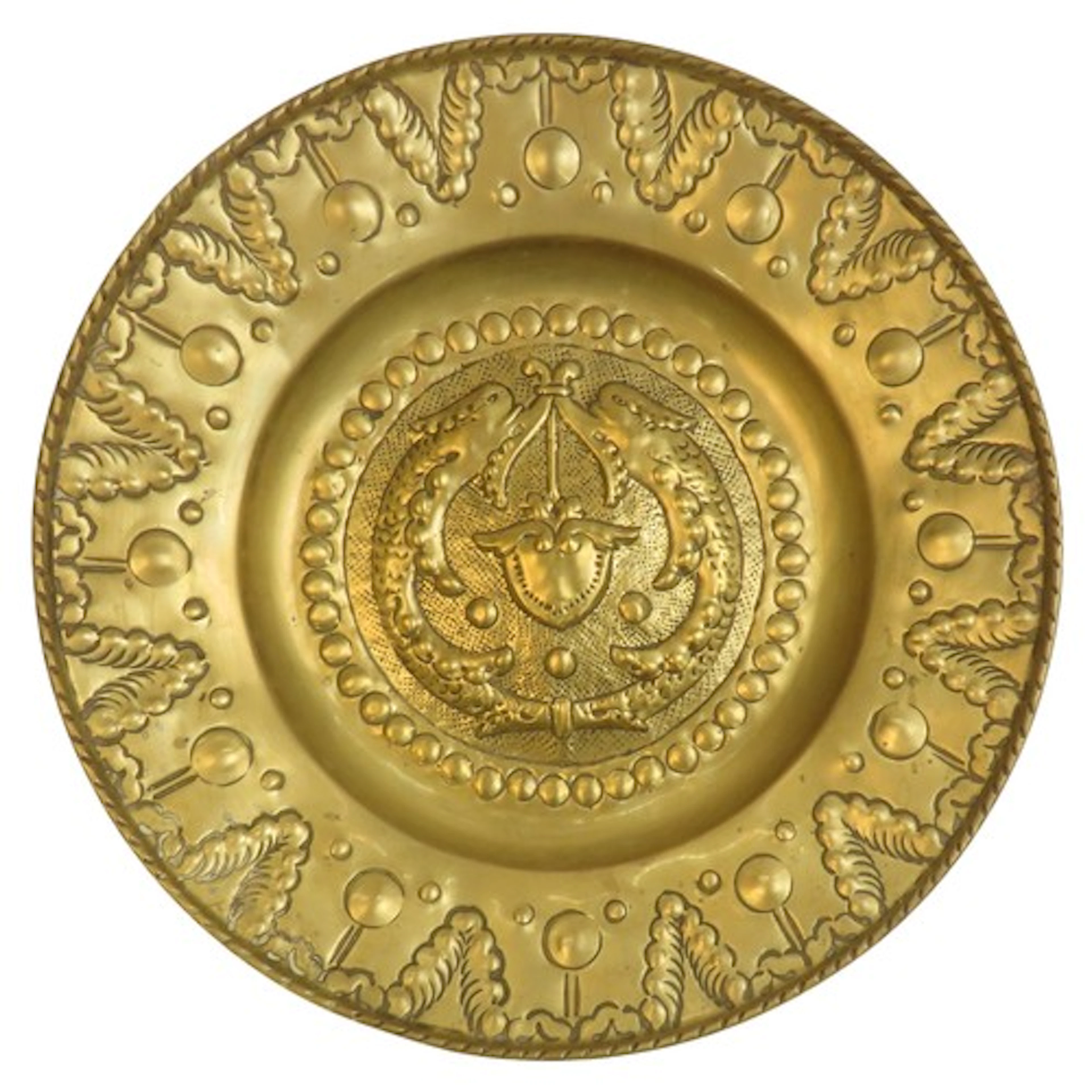 A BRASS REPOUSSE AND PINCH DECORATED ALMS DISH the center de...