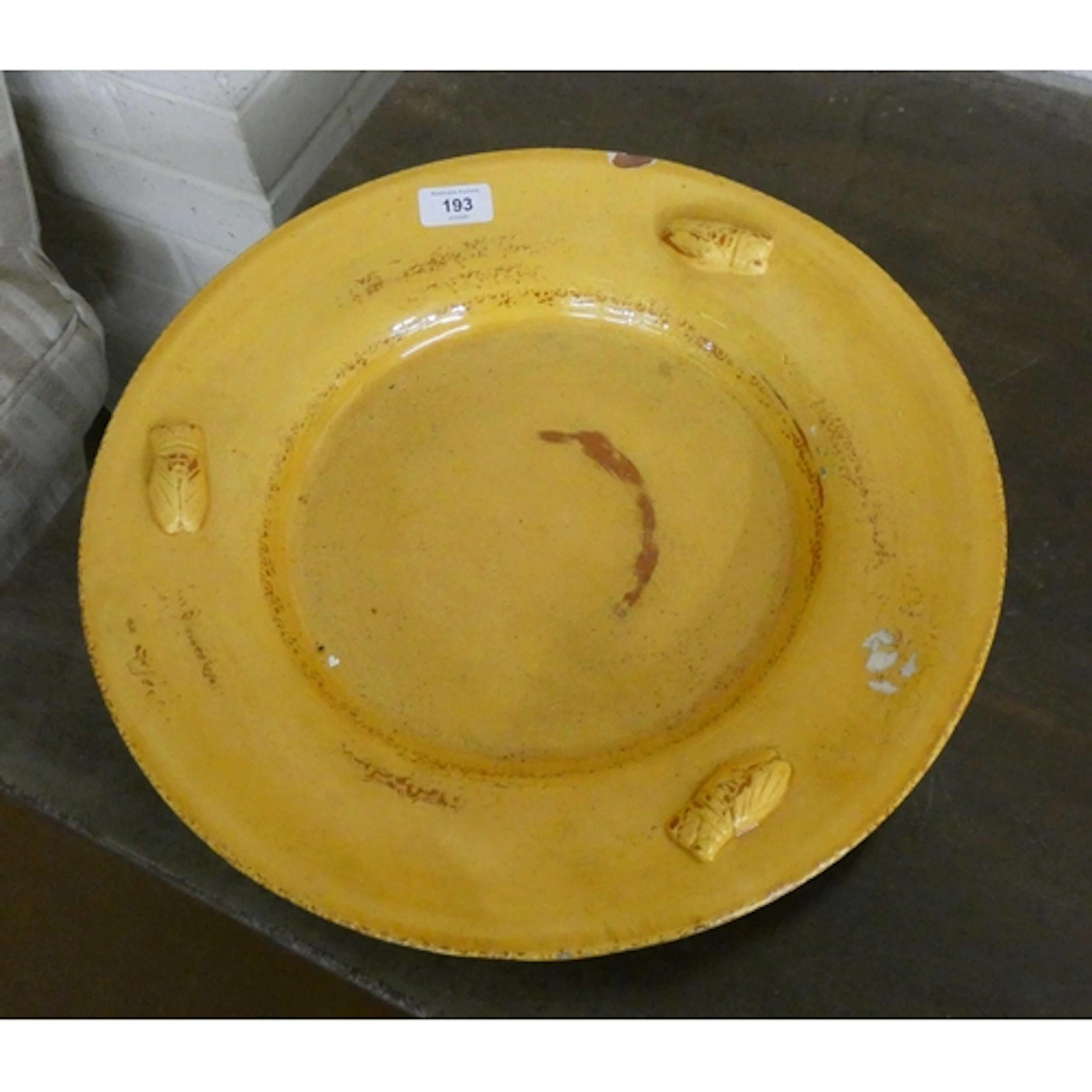 A French circular glazed terracotta plate moulded in relief ...