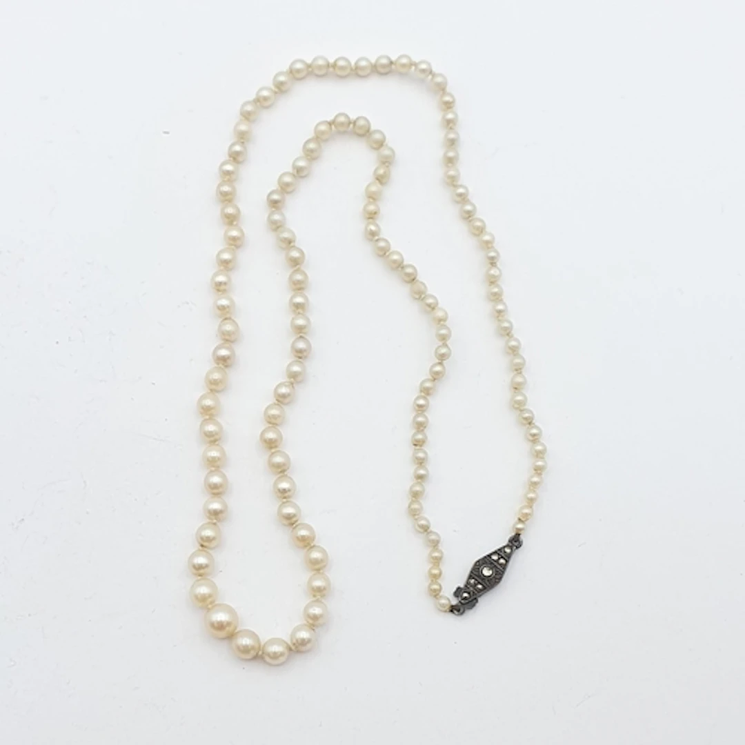 A graduated single strand cultured Pearl Necklace on a clasp...