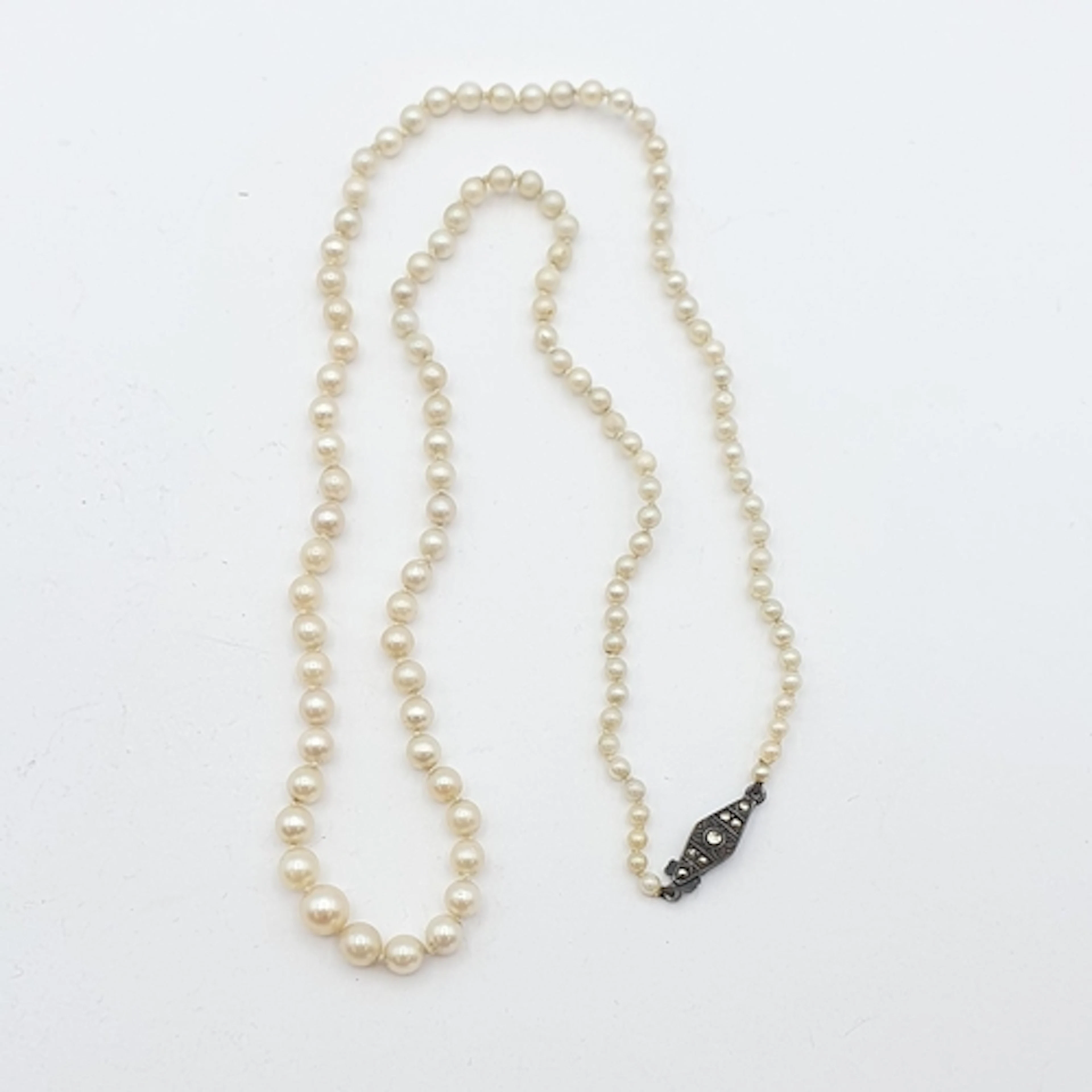 A graduated single strand cultured Pearl Necklace on a clasp...