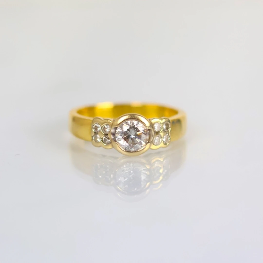 A contemporary 18ct yellow gold diamond ring, the central ro...