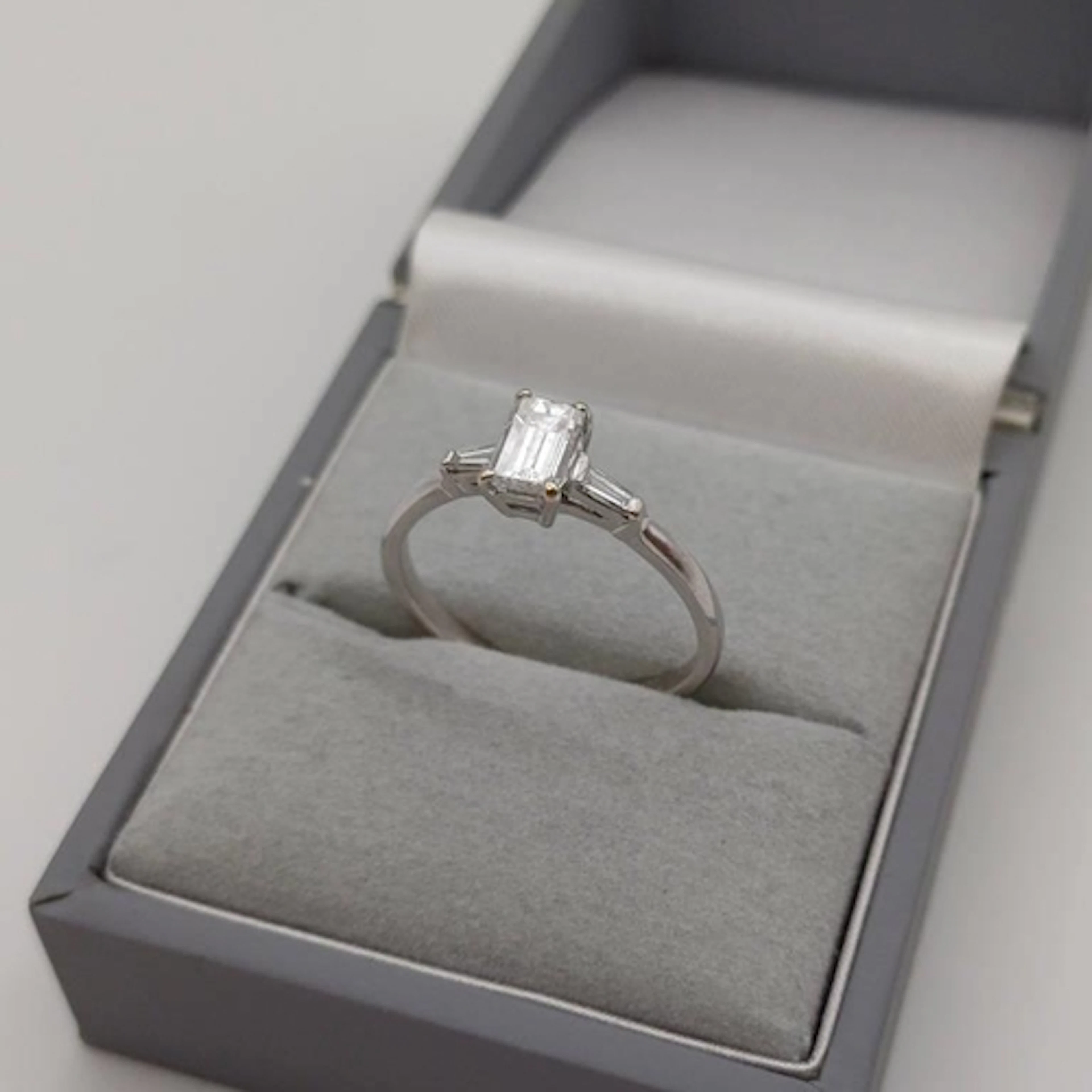 18CT GOLD DIAMOND SET RING, THE EMERALD CUT DIAMOND APPROX 0...