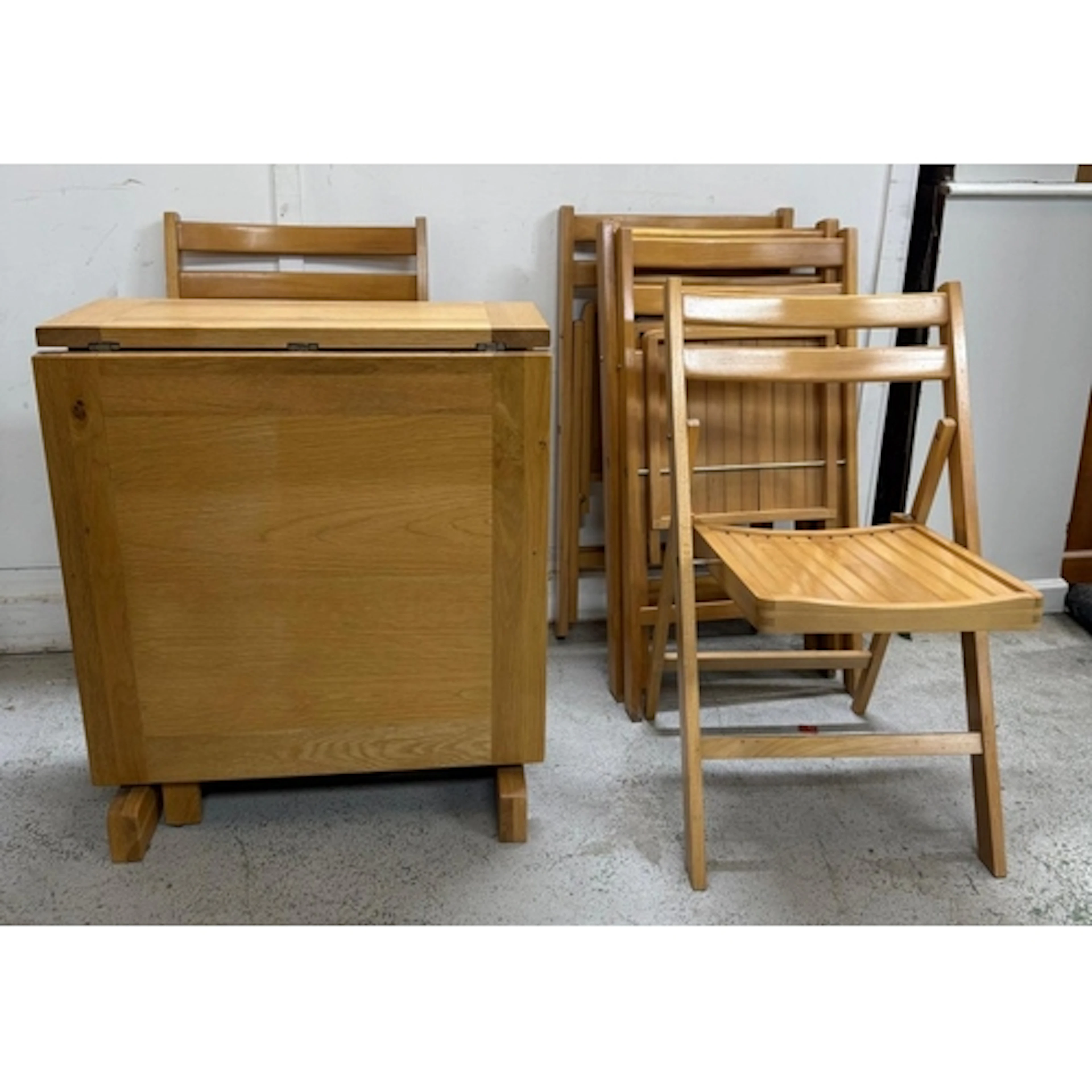 A light oak drop leaf dining table and six folding chairs...