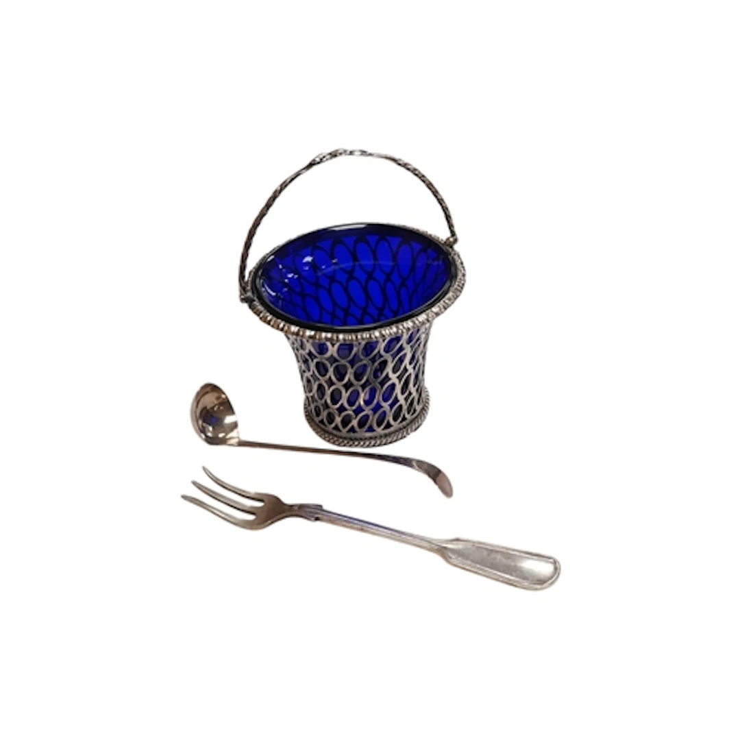 A George III pierced silver sugar basket with blue glass lin...