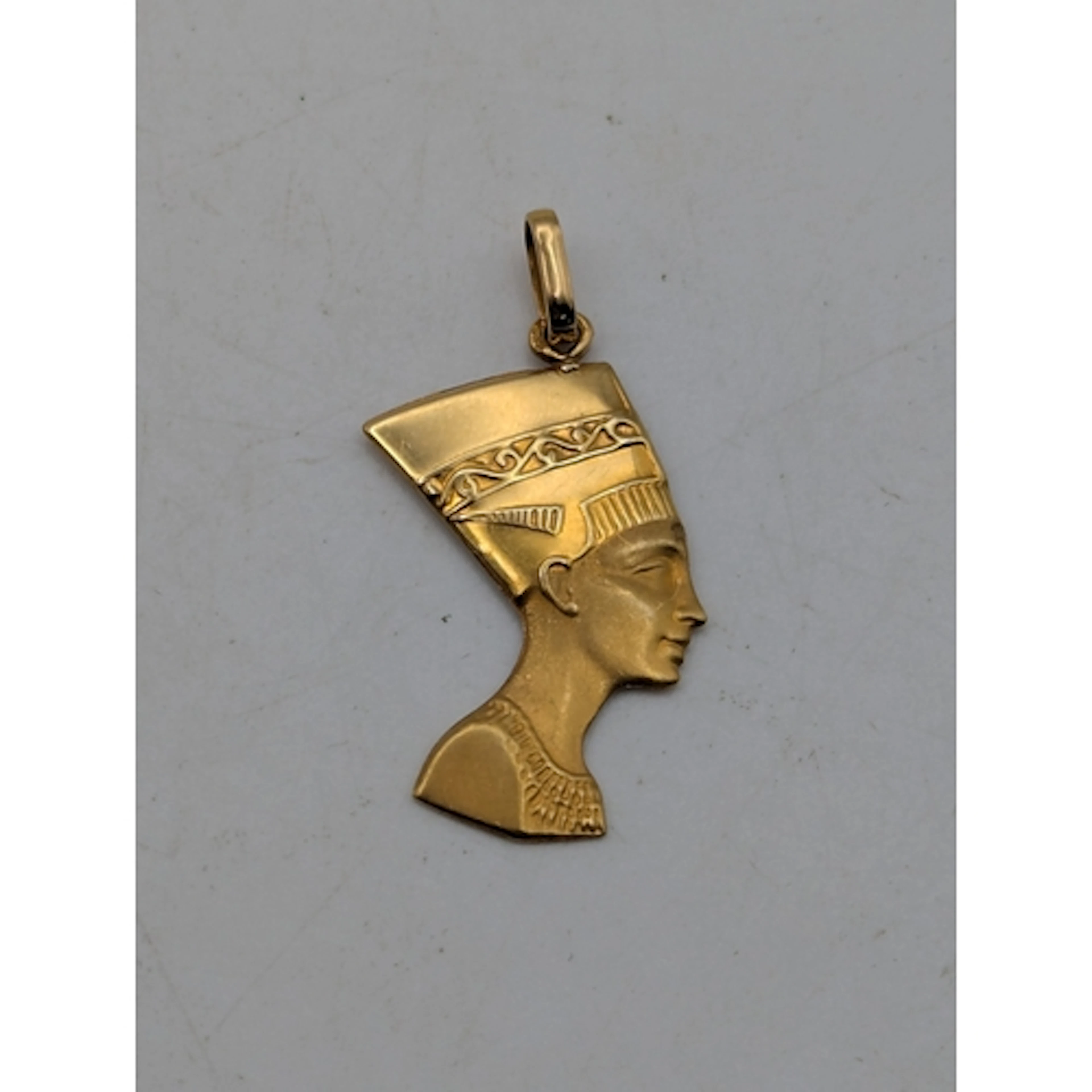 An 18ct yellow gold Queen Nefertiti profile pendant, with su...
