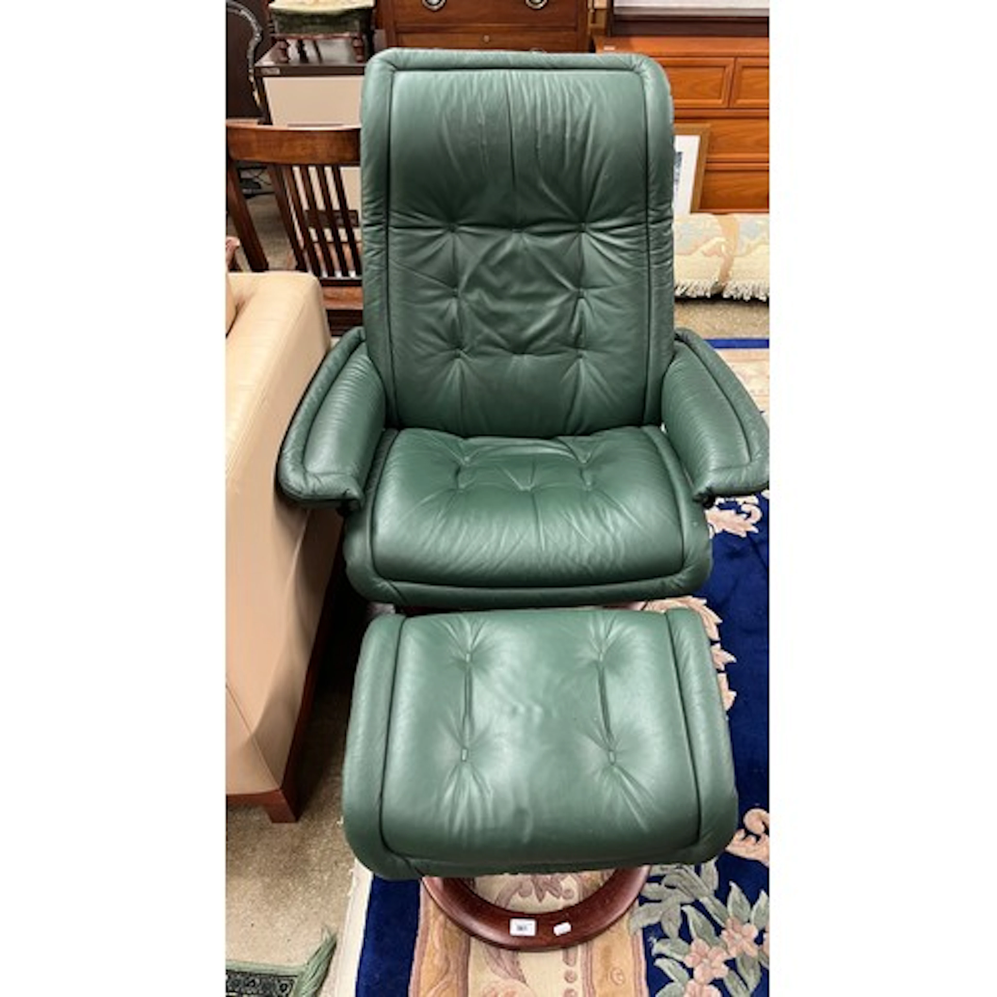 Stressless green leather swivel chair and stool.