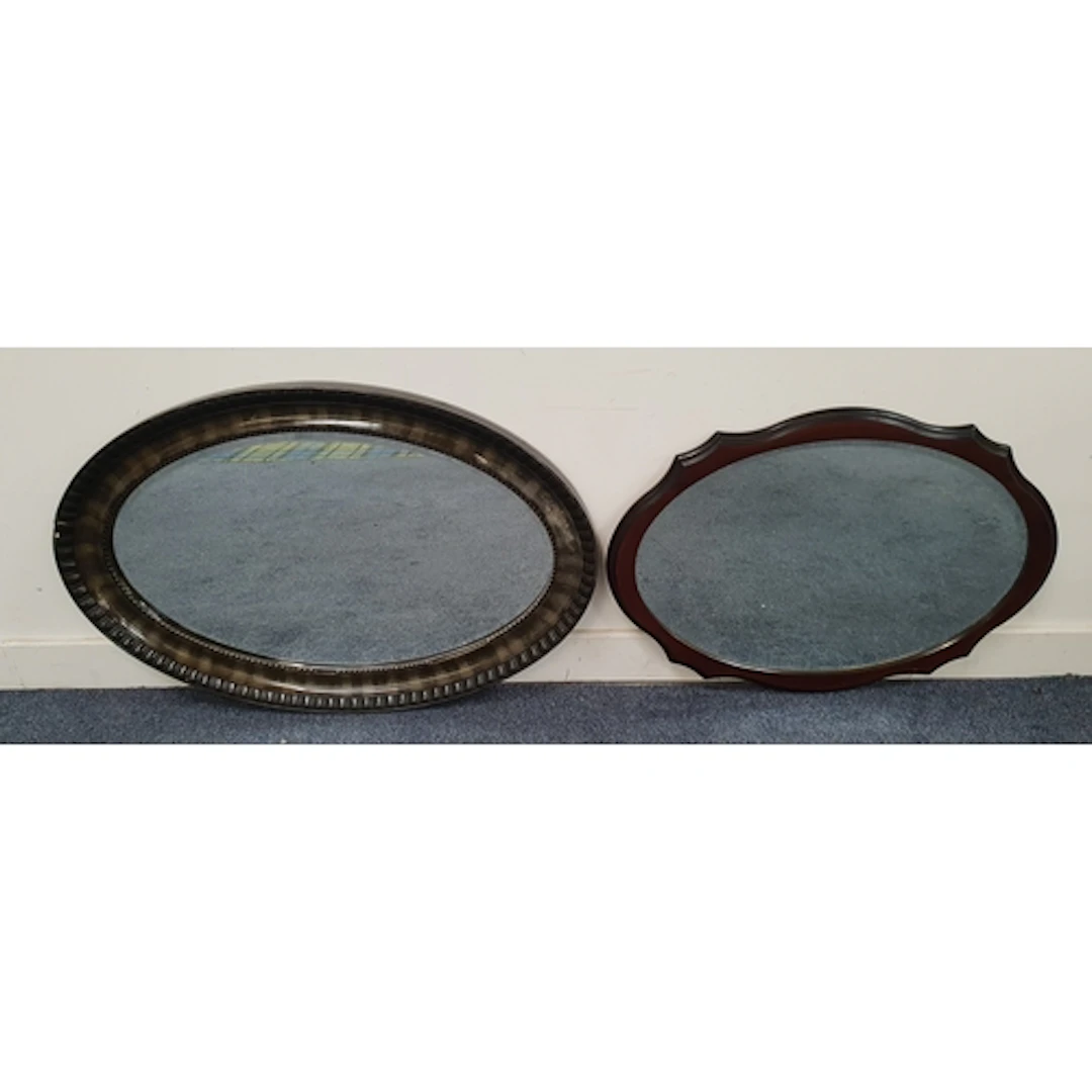 TWO BEVELLED WALL MIRRORS comprising an oval wall mirror wi...