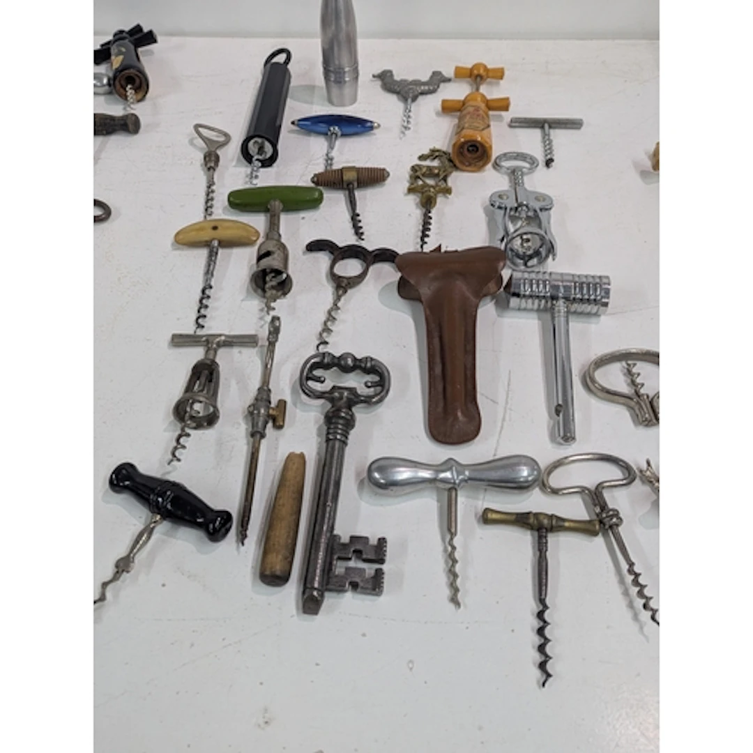 A collection of vintage corkscrews and bottle openers, one f...