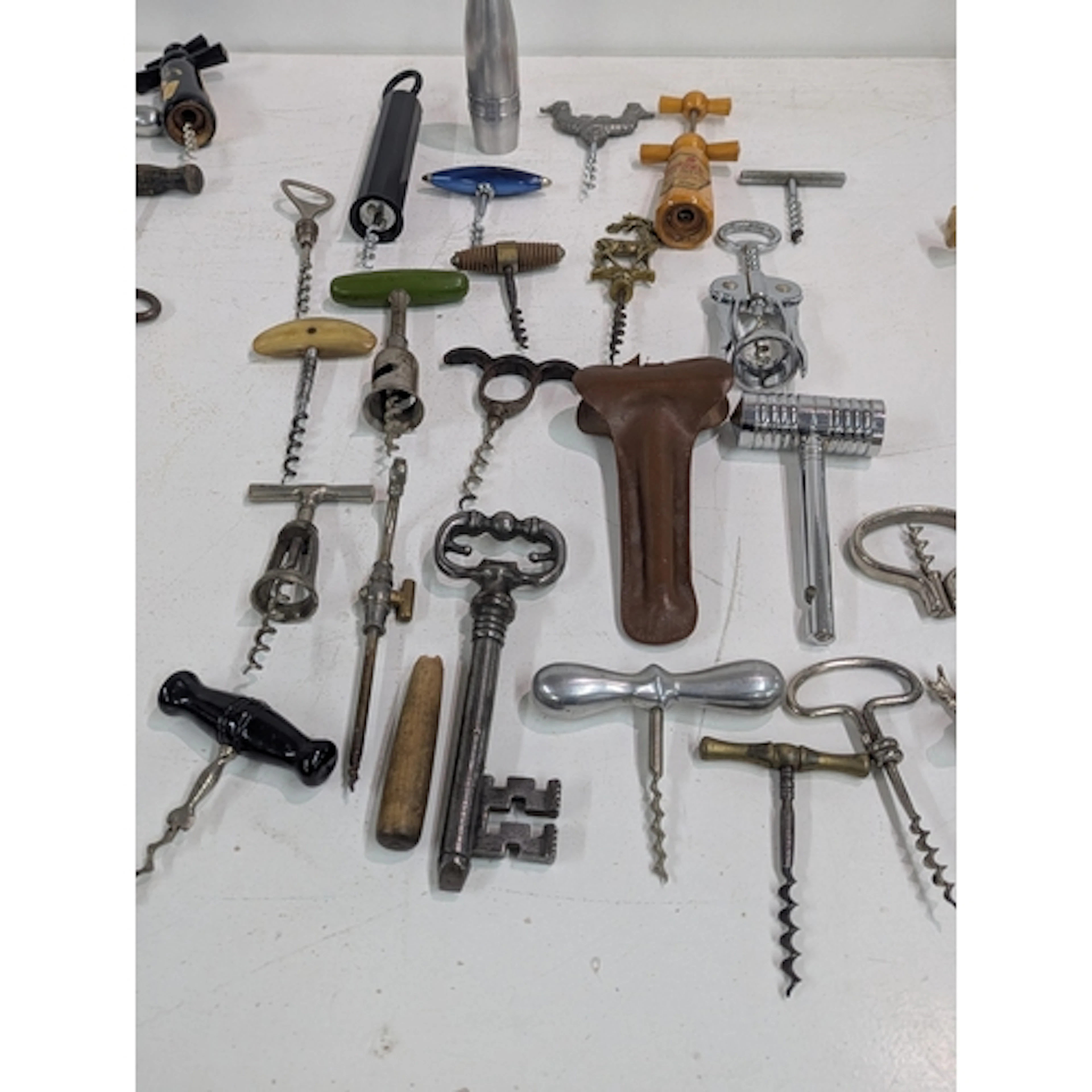 A collection of vintage corkscrews and bottle openers, one f...