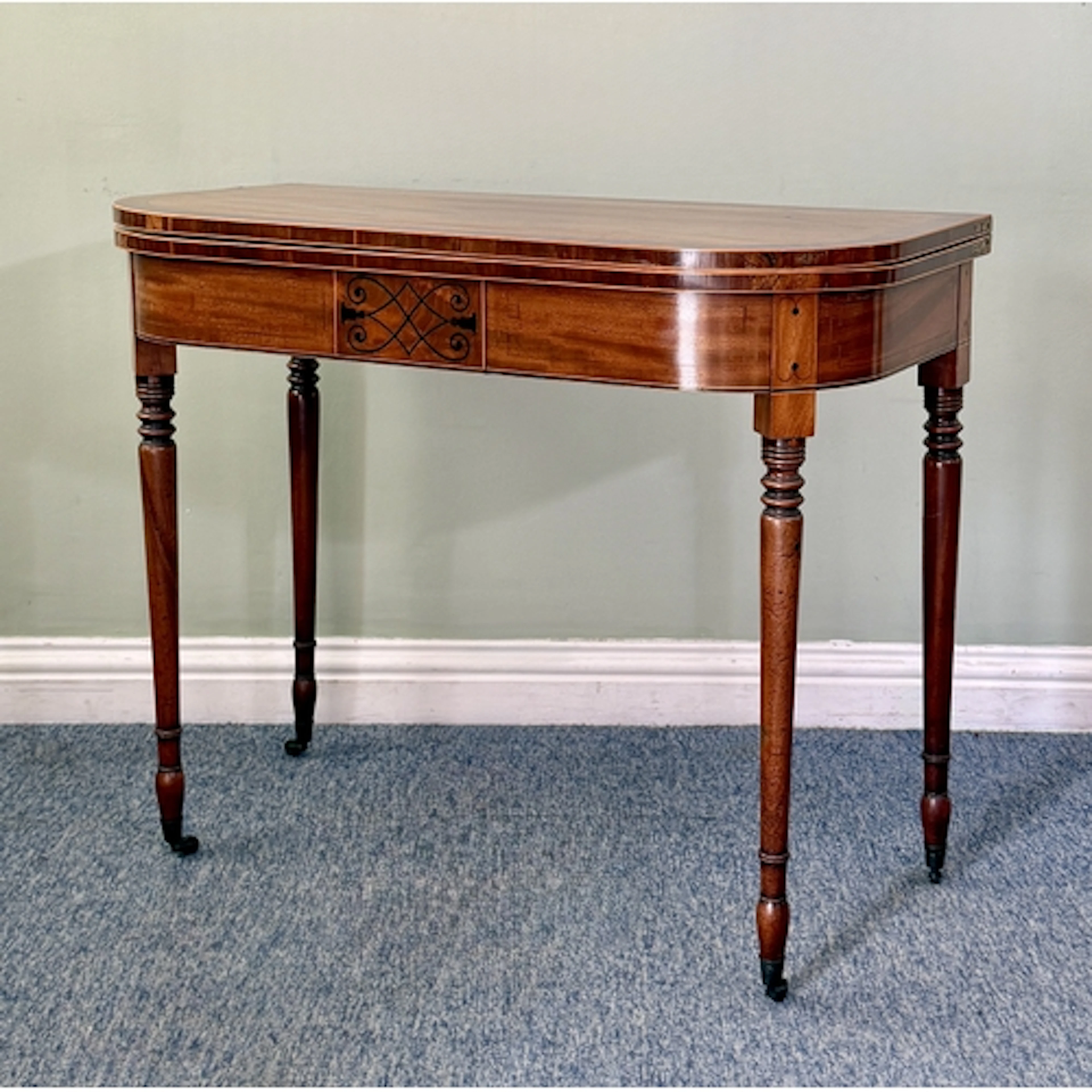 A George IV mahogany D-shaped card table - the cross banded ...
