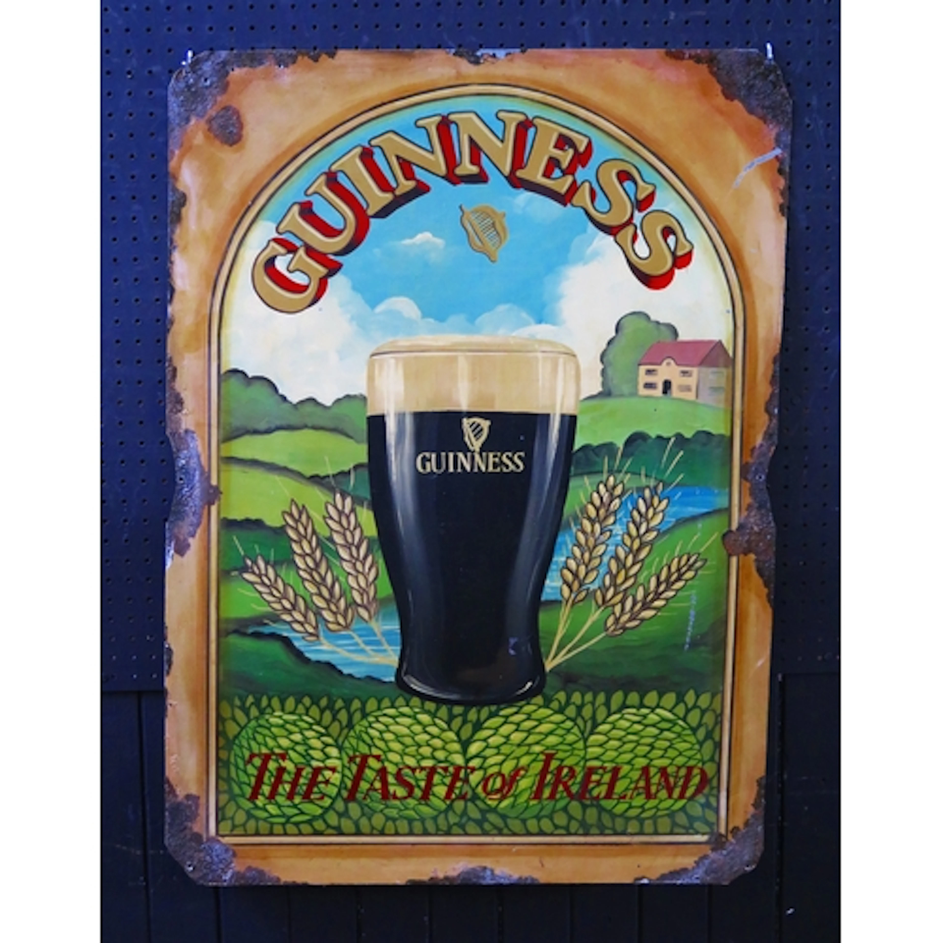 "Guinness - The Taste of Ireland" - a metal and hand painted...