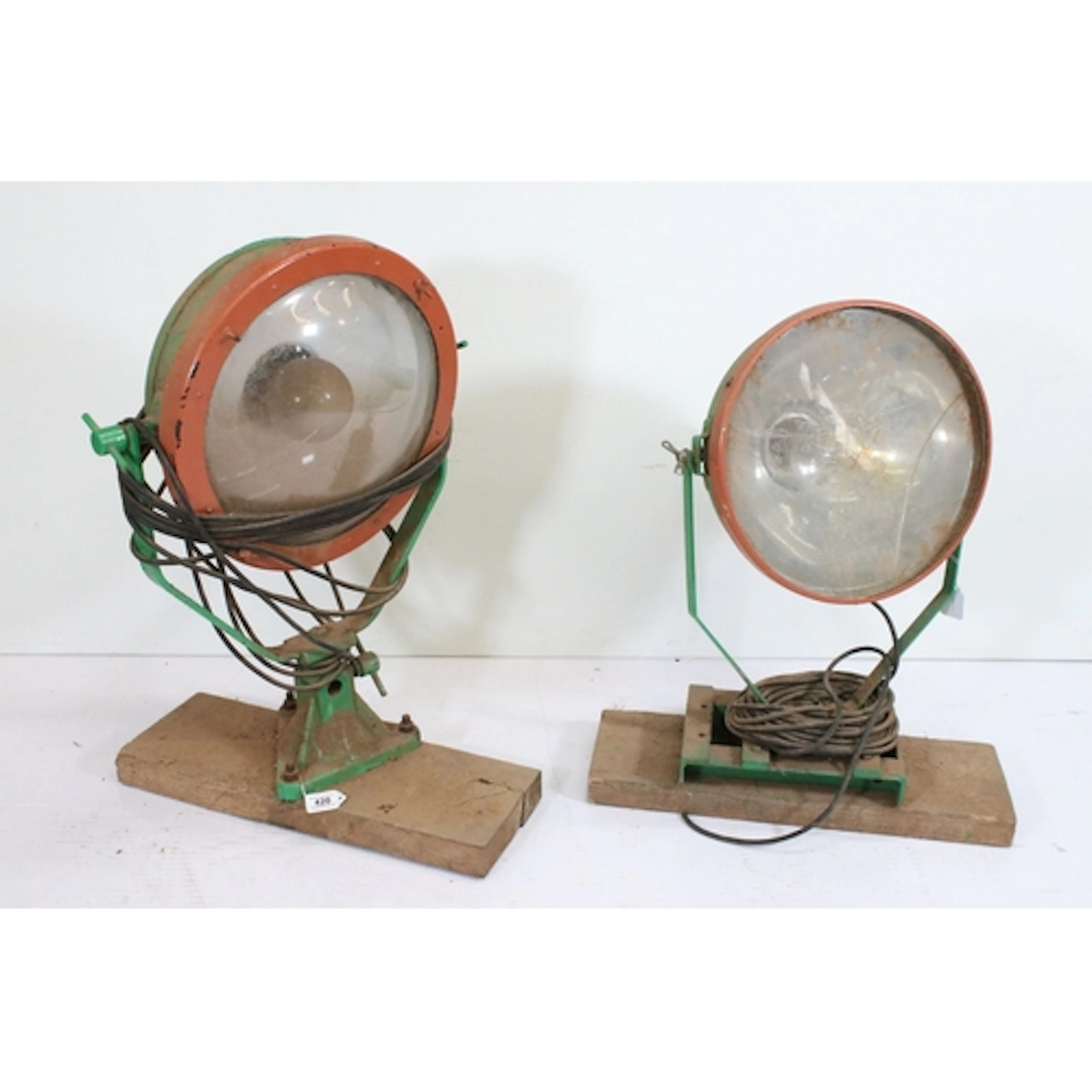 Two green painted industrial searchlight or flood light, bot...