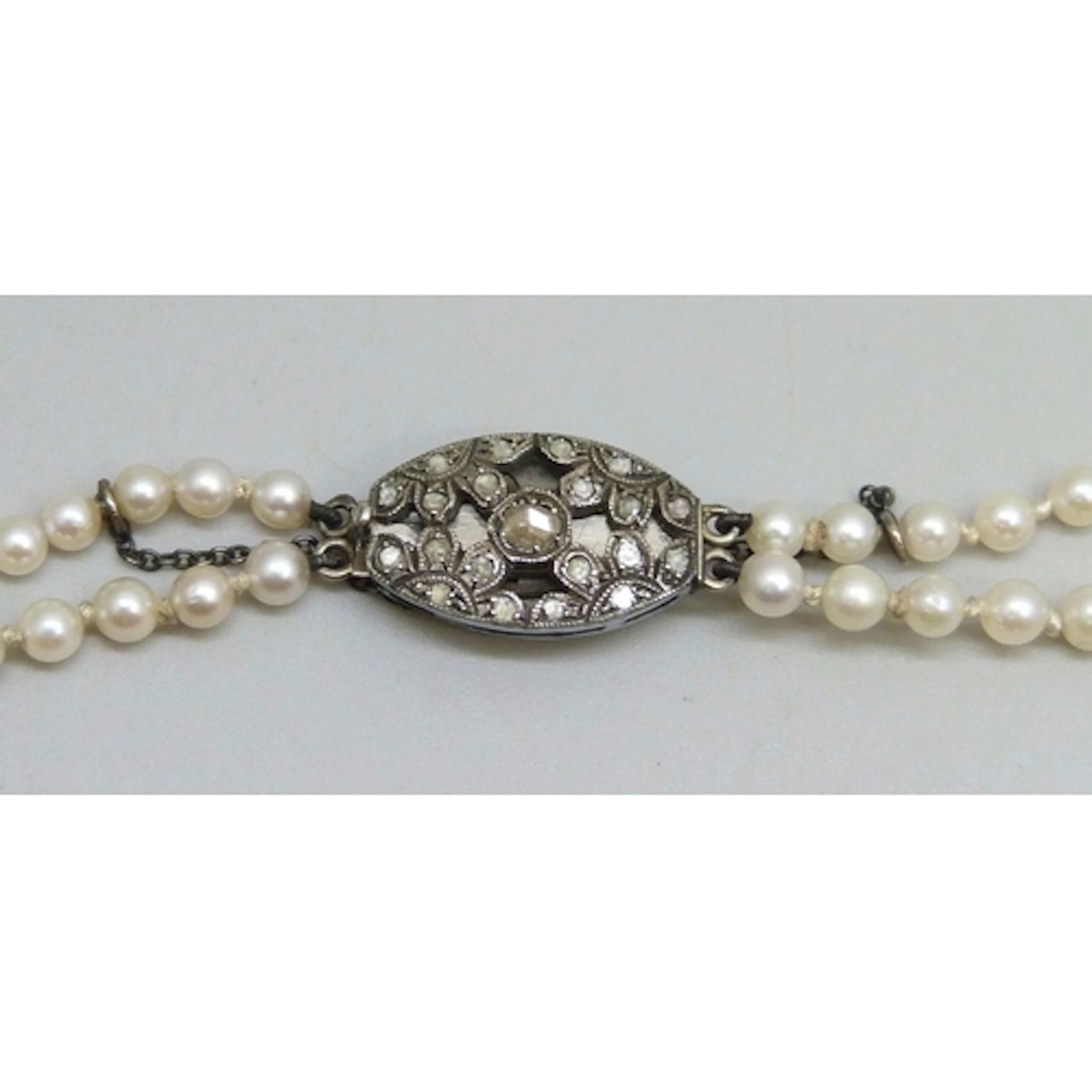 A two strand cultured pearl necklace with a white metal clas...